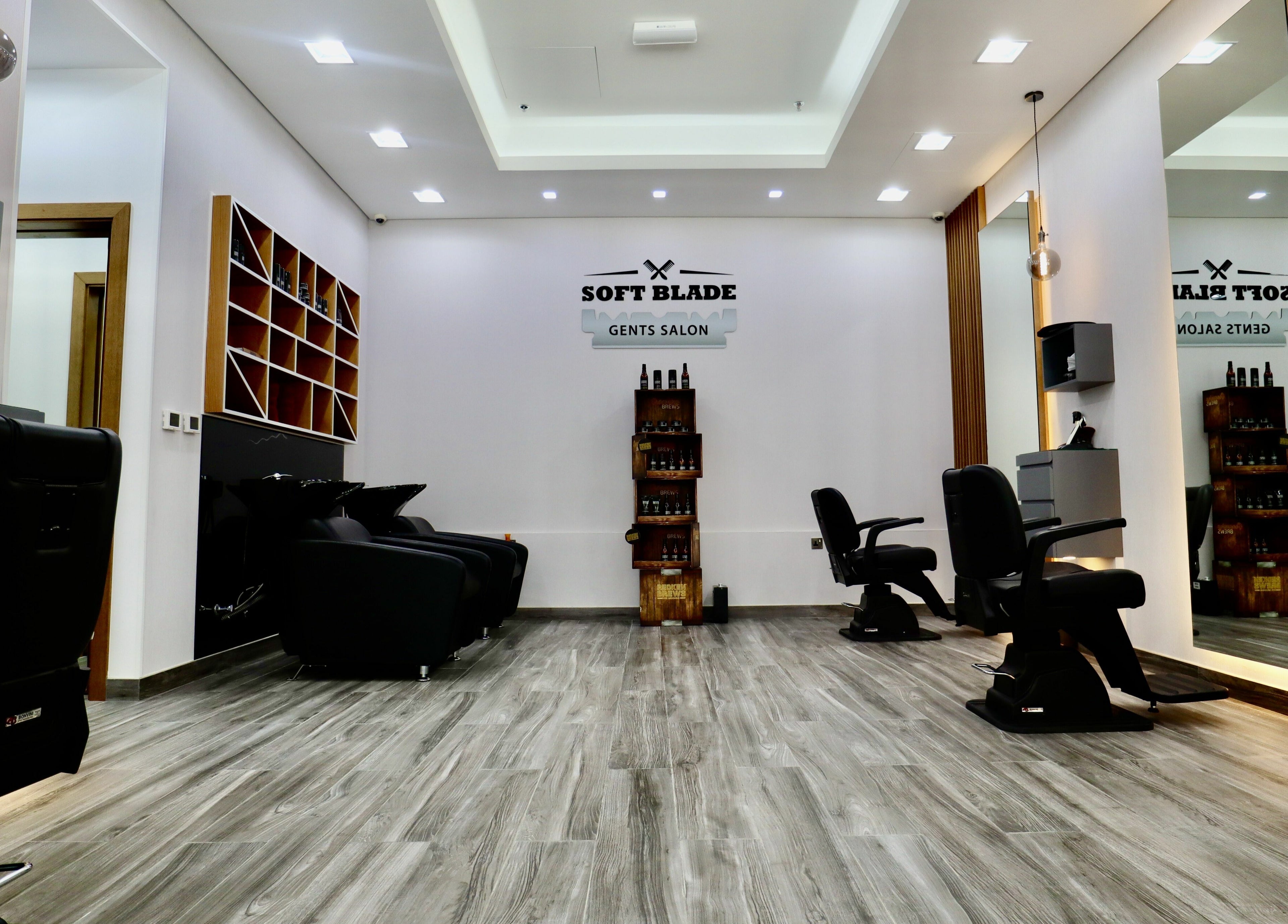 Modern interior of Soft Blade Gents Salon in Dubai, Dubai, AE with sleek black chairs and stylish décor.