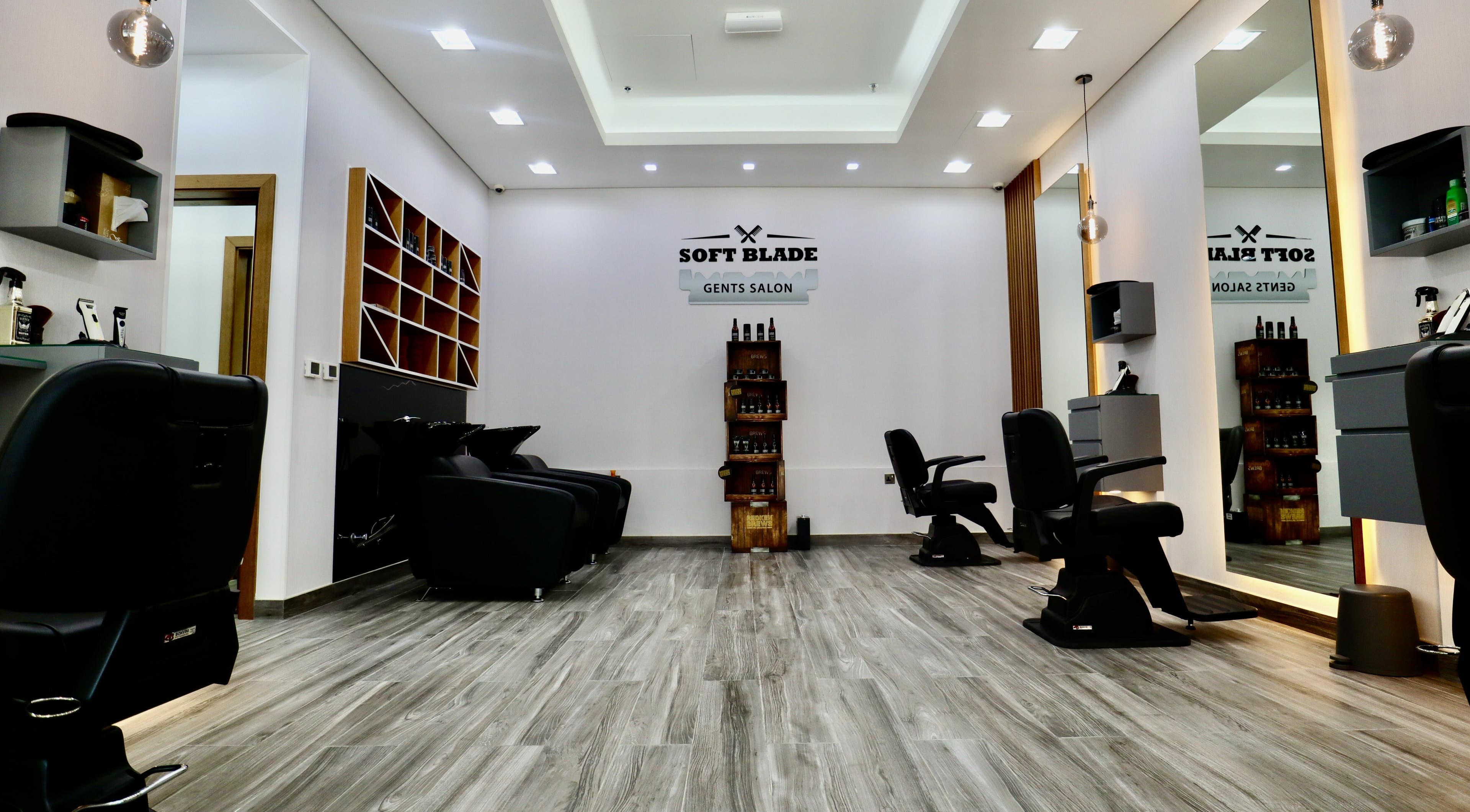 Modern interior of Soft Blade Gents Salon in Dubai, Dubai, AE with sleek black chairs and stylish décor.