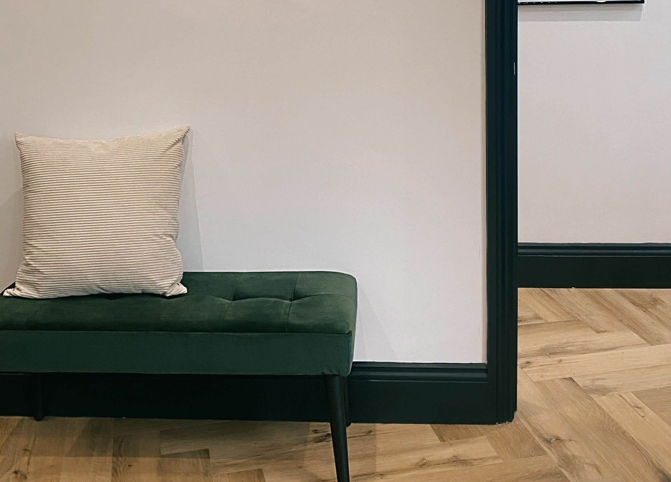 Elegant green bench with pillow at Leanne Alexandra, Bolton, England, GB. Interior design detail.