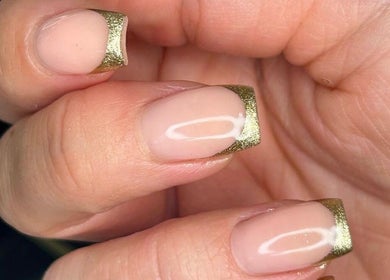 Gold-tipped manicured nails at The Bella Lounge, Plymouth, England, GB, showcasing elegant nail design.