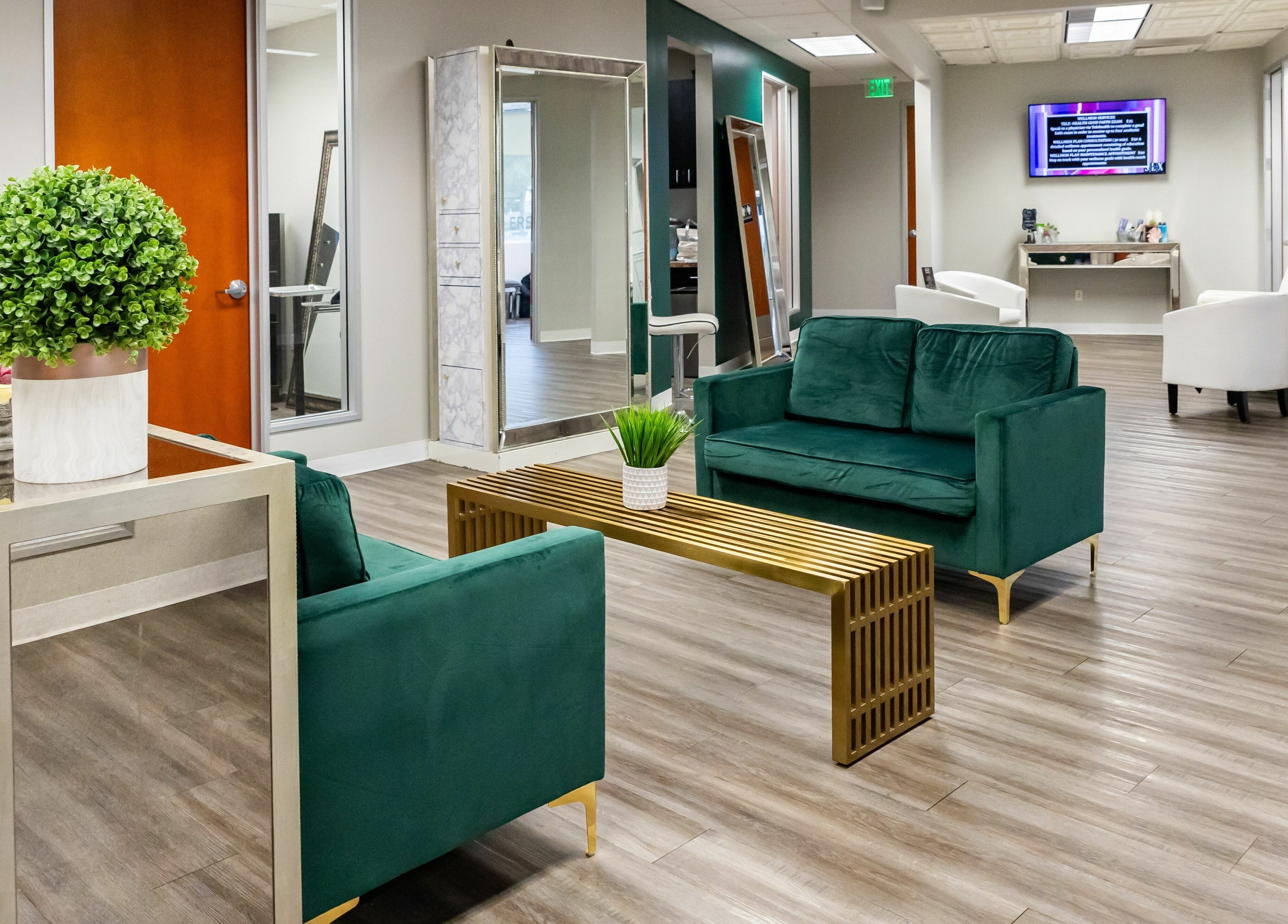 Modern lounge area at So Luxe Salon, Rancho Cucamonga, California, US, with green sofas and chic decor.
