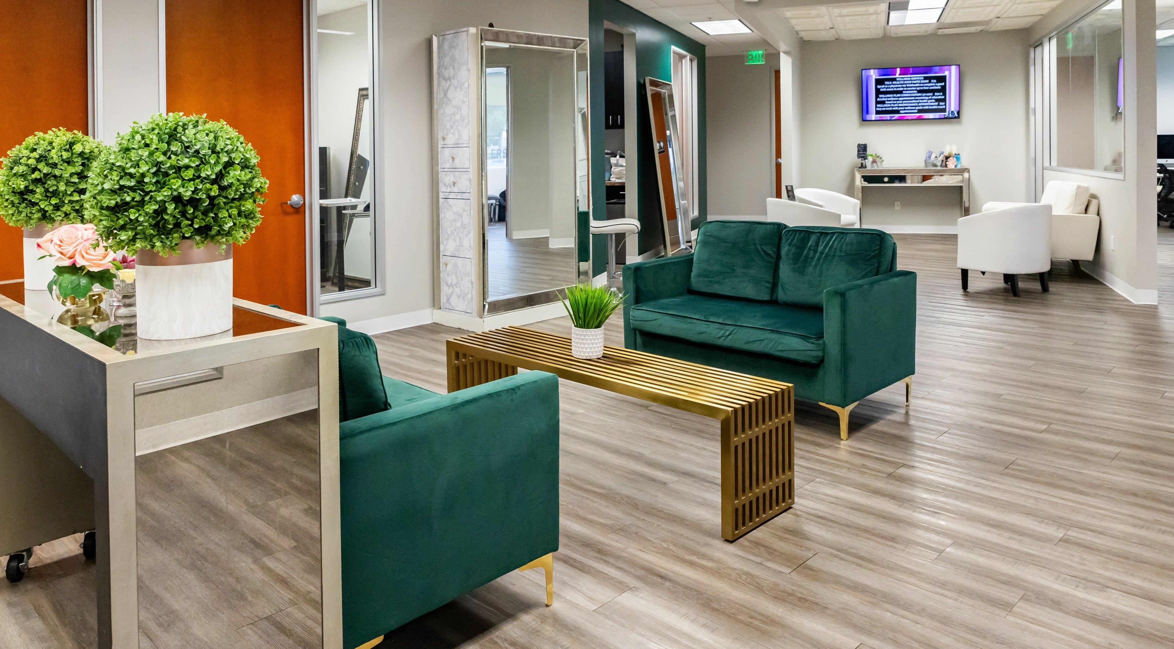 Modern lounge area at So Luxe Salon, Rancho Cucamonga, California, US, with green sofas and chic decor.