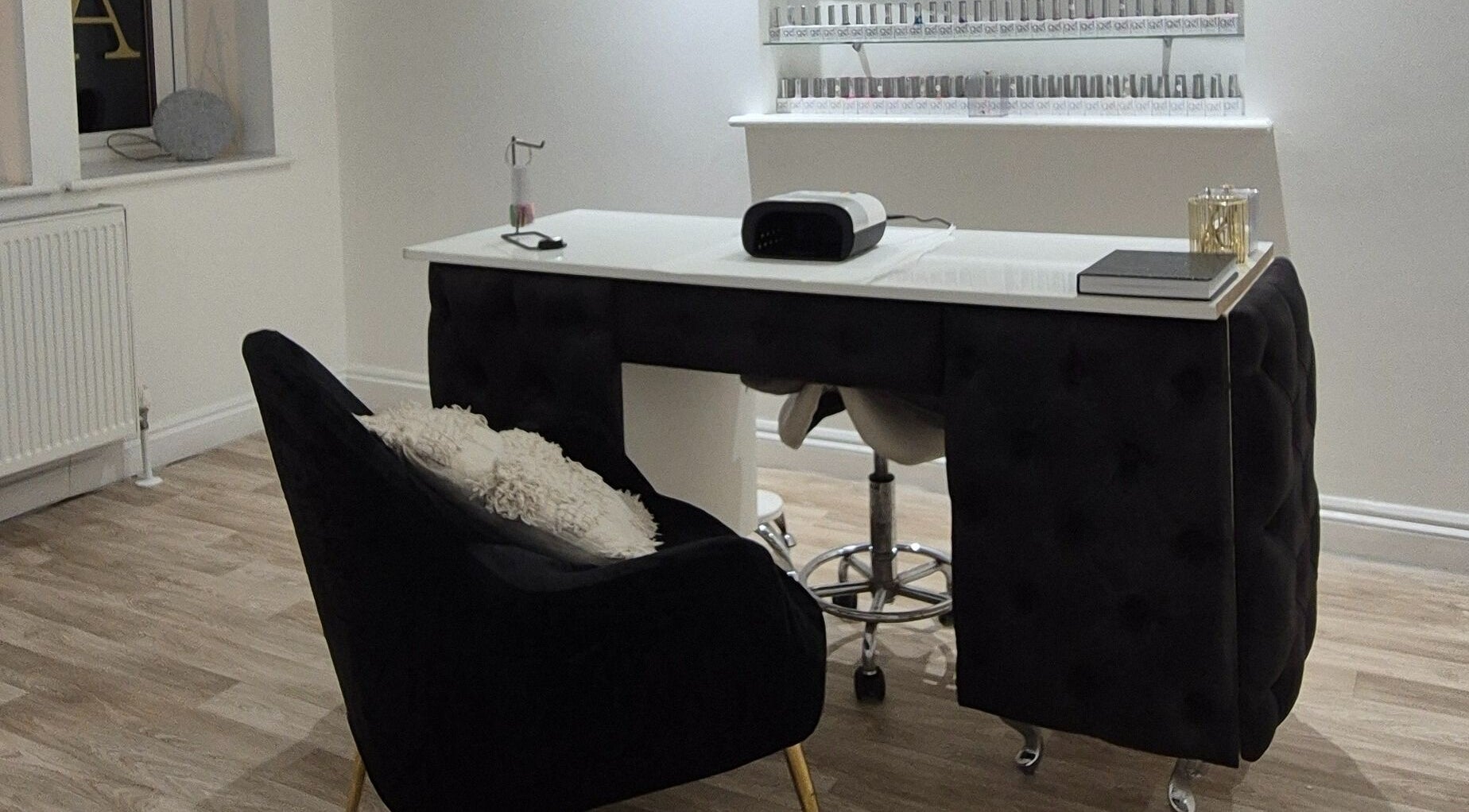 Chic nail studio at Meraki in Shaw, England, GB featuring a modern manicure setup and shelves of nail polish.