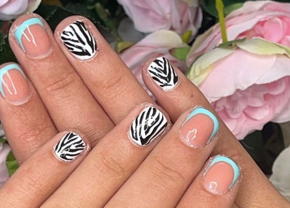 Stylish zebra and blue nail art at Meraki, Shaw, England, GB. Perfect for chic and modern beauty lovers.