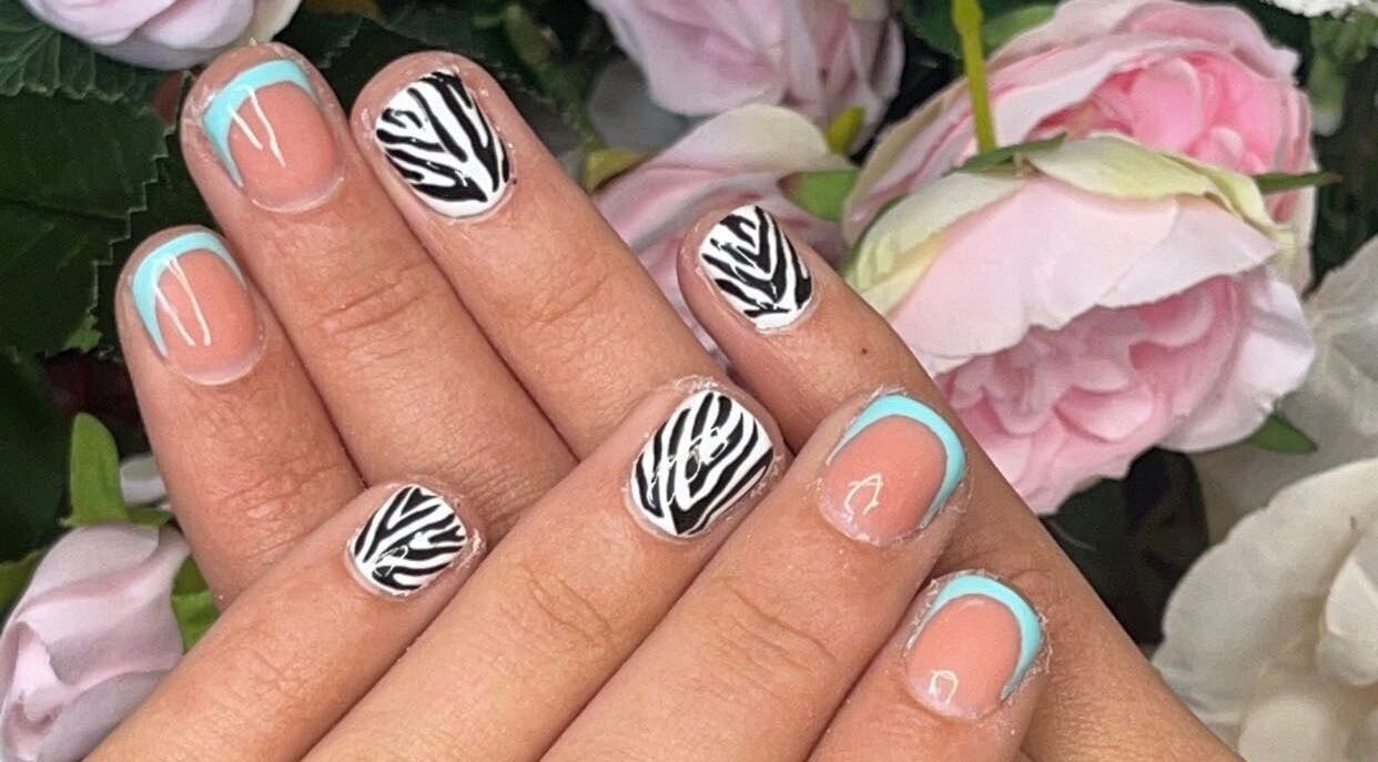 Stylish zebra and blue nail art at Meraki, Shaw, England, GB. Perfect for chic and modern beauty lovers.