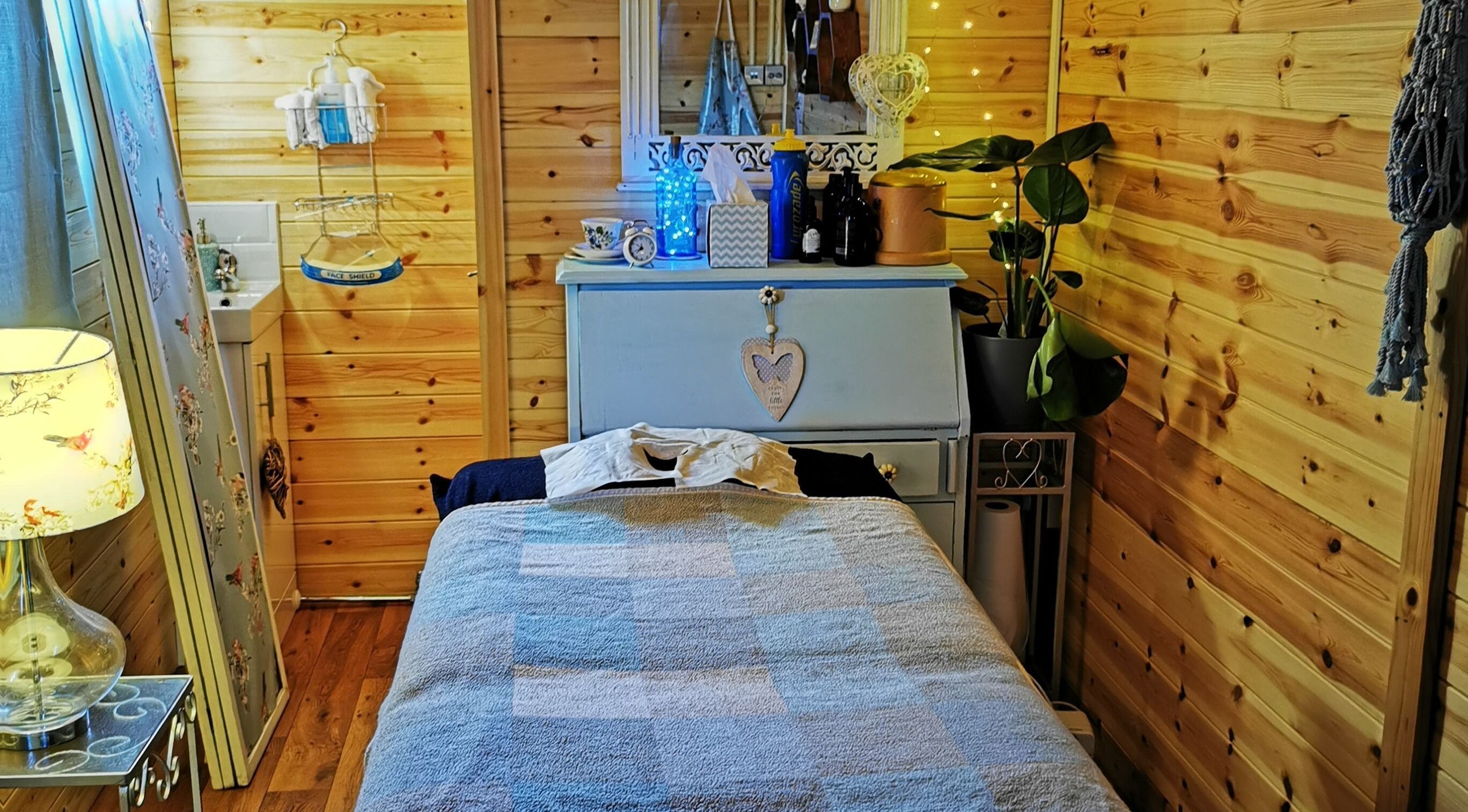 Tranquil massage room at Essence Mind and Body, Leeds, England, GB with wooden interiors and soft lighting.