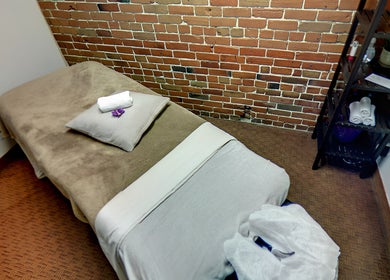 Salle de massage confort à Studio Orchidée, Montréal, Québec, CA, avec décor en brique apparente.