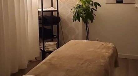 Salle de massage apaisante à Studio Orchidée, Montréal, Québec, CA, avec table et plante verte.