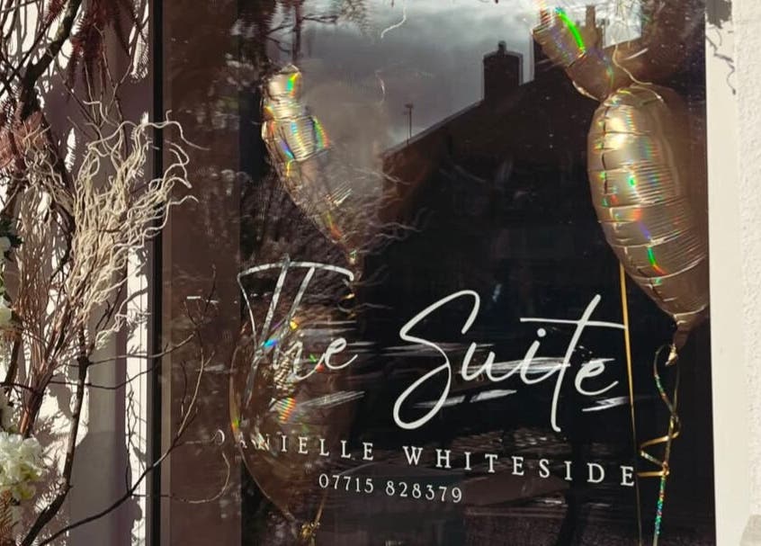 Front window display of The Suite in Garstang, England with floral and balloon decor.