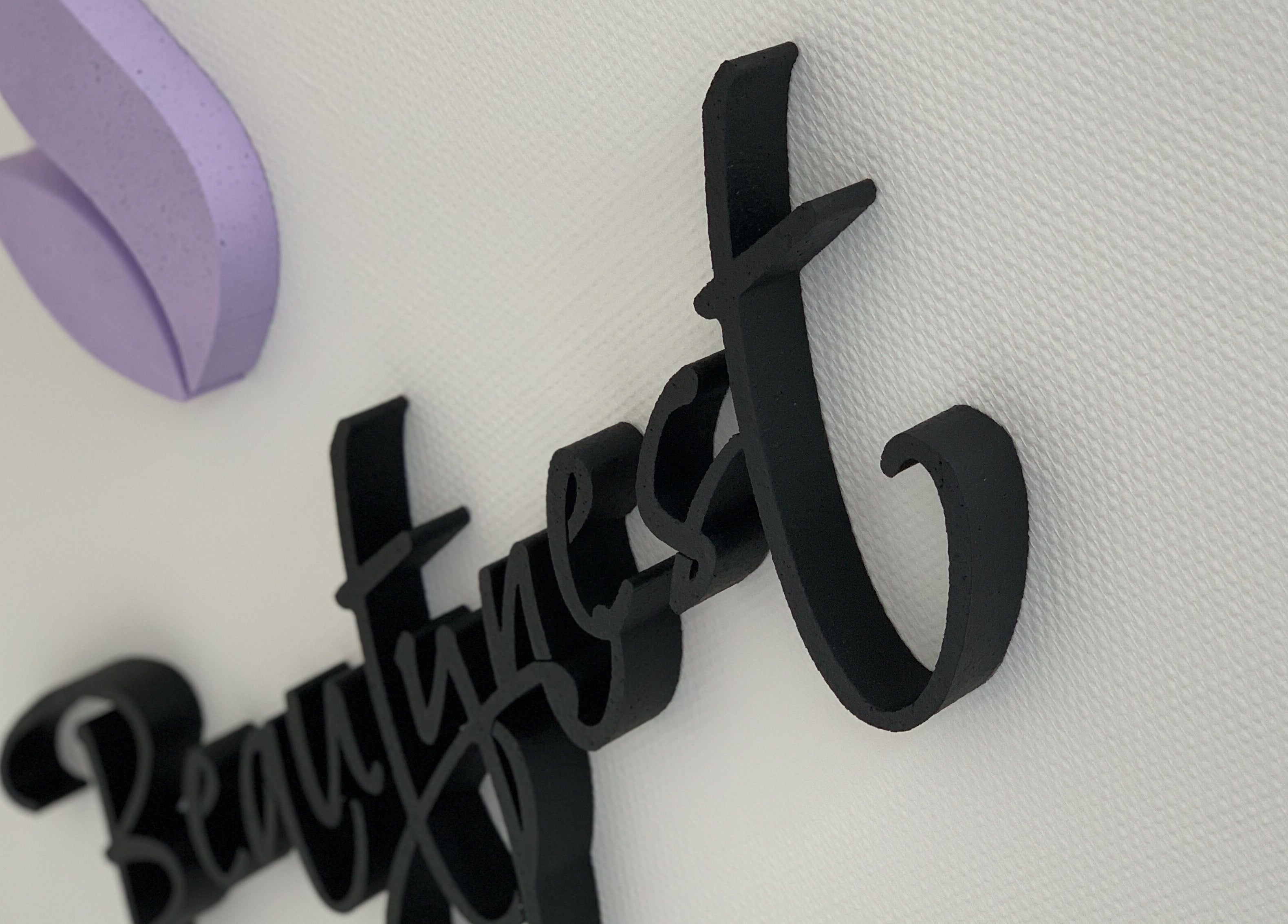 3D muurlogo van Beautynest in Herent, Vlaanderen, BE met paarse decoratie.