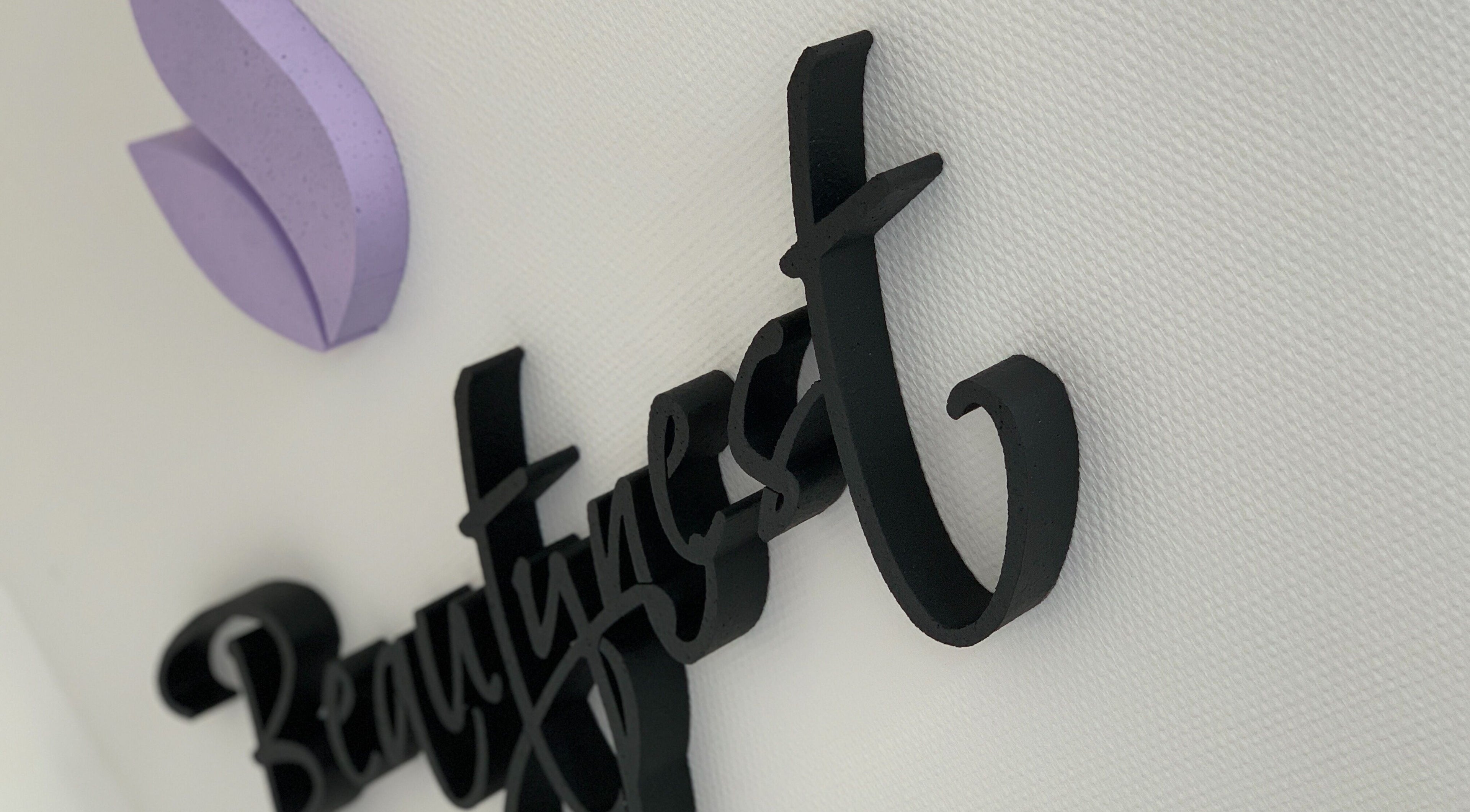 3D muurlogo van Beautynest in Herent, Vlaanderen, BE met paarse decoratie.