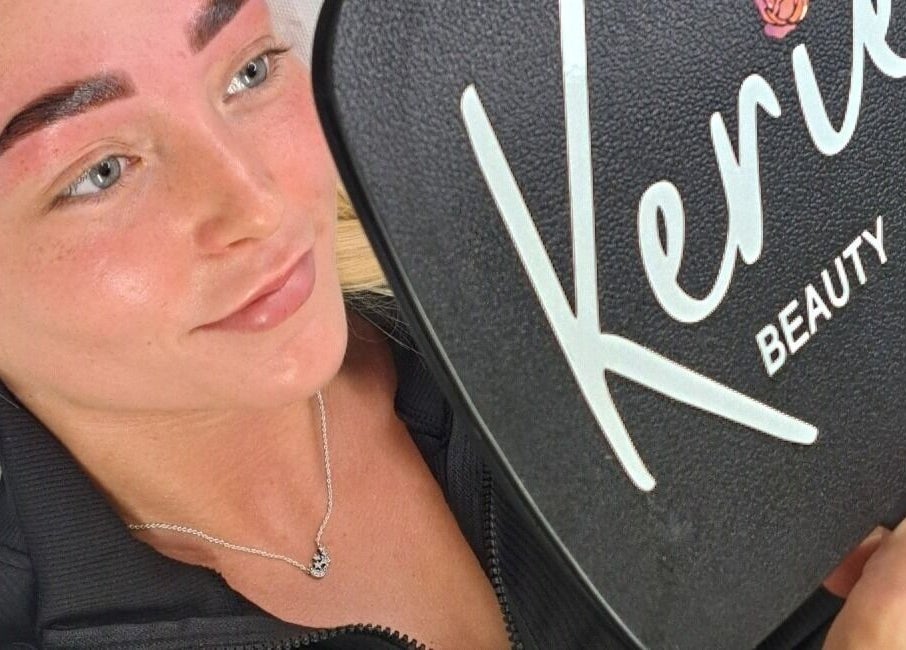 Client admiring brows in Kerie Beauty mirror, Saint Asaph, Wales, GB, showcasing stunning results.