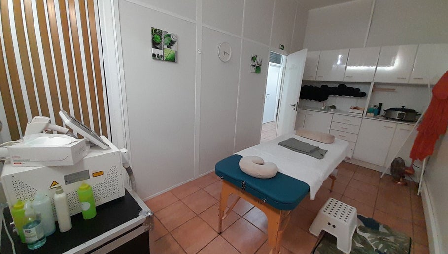 Sala de tratamento em Cor Purpura - Ovar, São João de Ovar, Aveiro, PT com mesa de massagem e equipamento de estética.