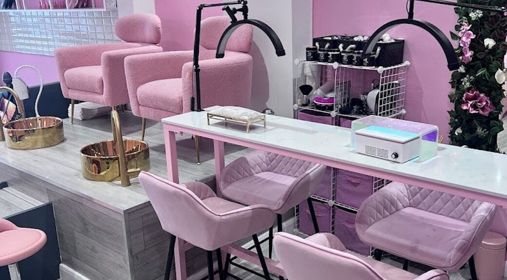 Interior of TK Beauty Bank in London, England, GB, featuring plush pink chairs and elegant manicure stations.