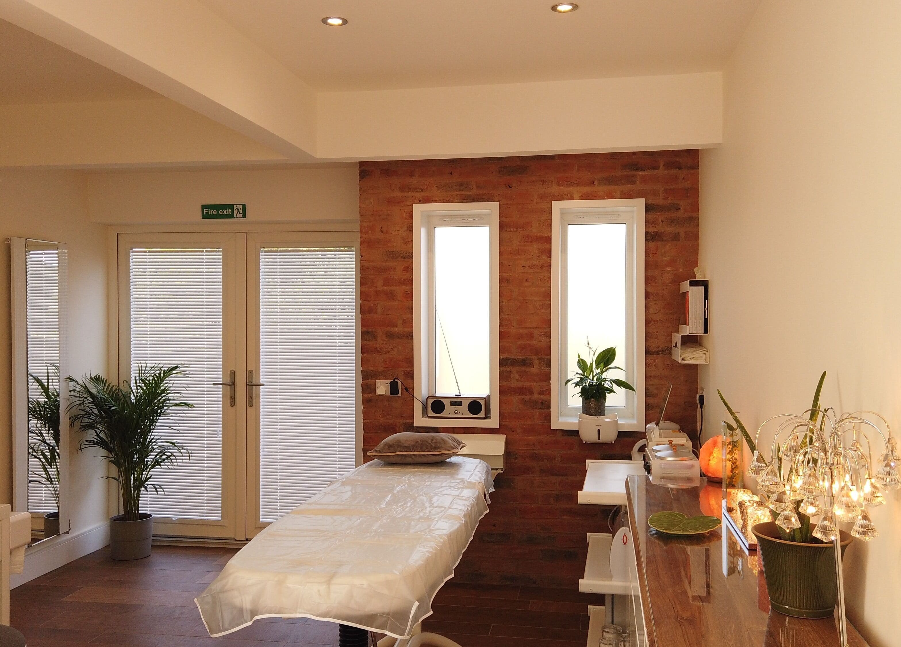 A tranquil treatment room at Anstey Beauty in Leicester, England, GB, featuring a massage bed and serene decor.