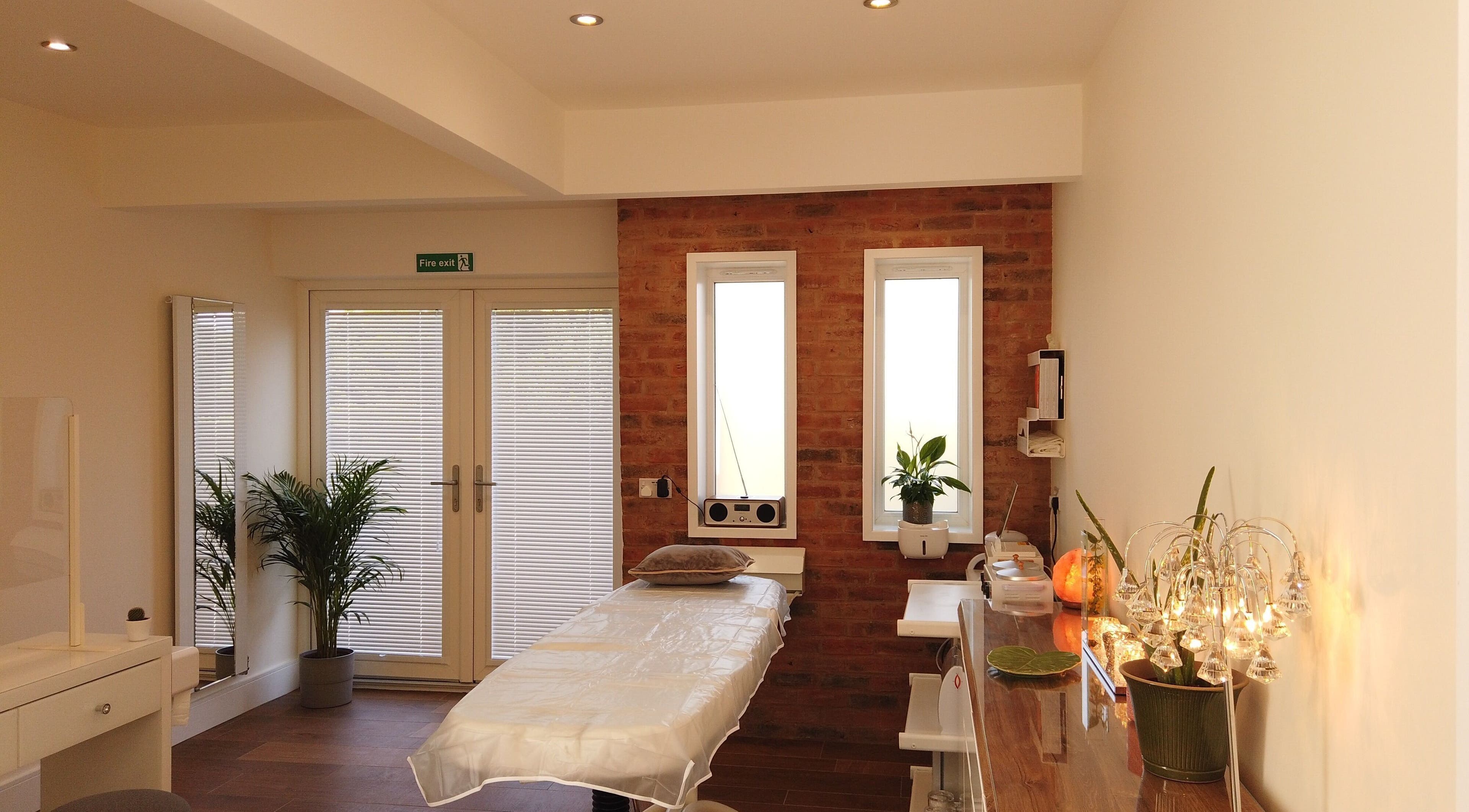 A tranquil treatment room at Anstey Beauty in Leicester, England, GB, featuring a massage bed and serene decor.