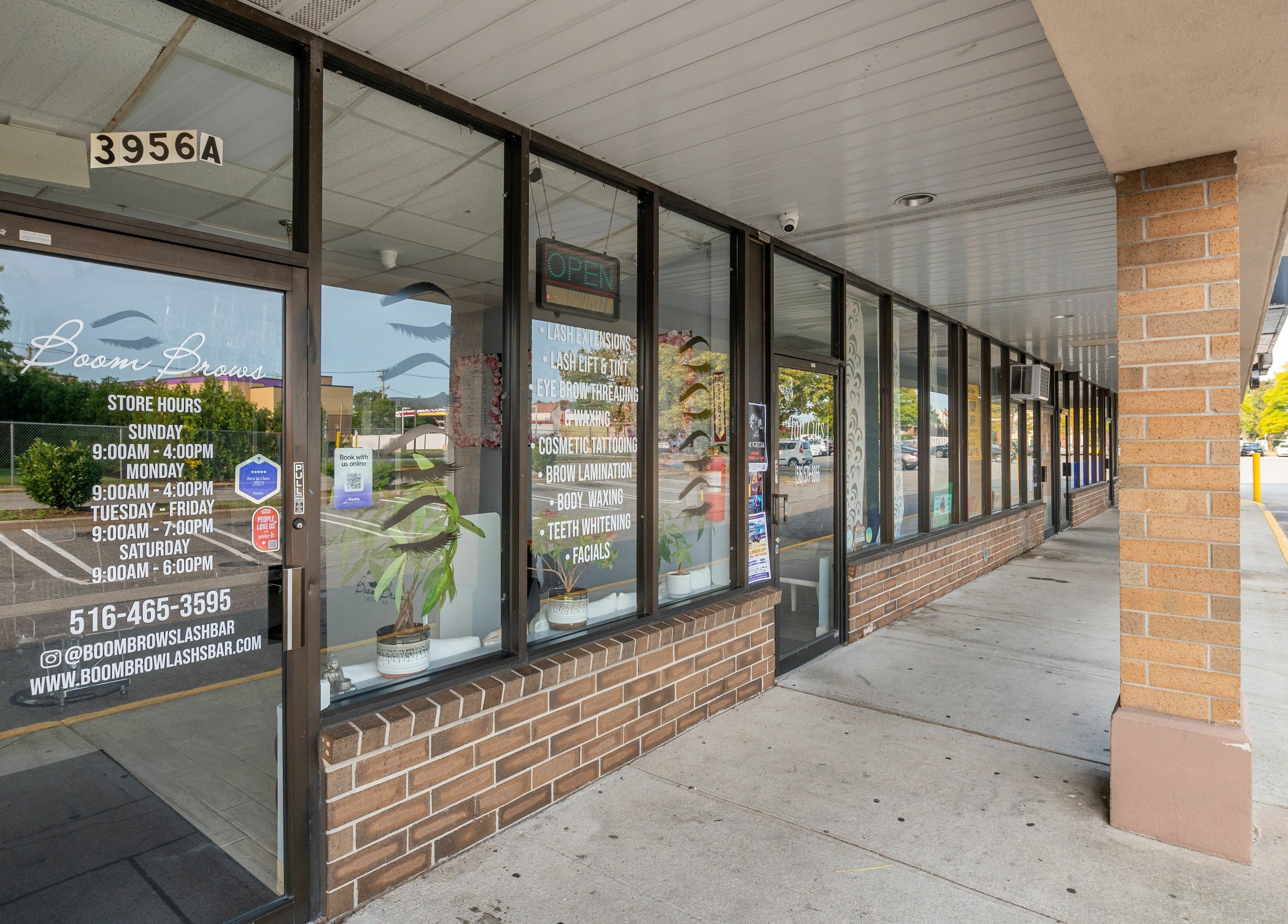 Front view of Boom Brows Lash Bar in Bethpage, New York, US with store hours and services listed.