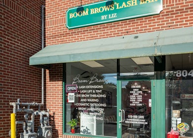 Front view of Boom Brows Lash Bar By Liz in Massapequa Park, New York, US. Brick exterior and glass doors.