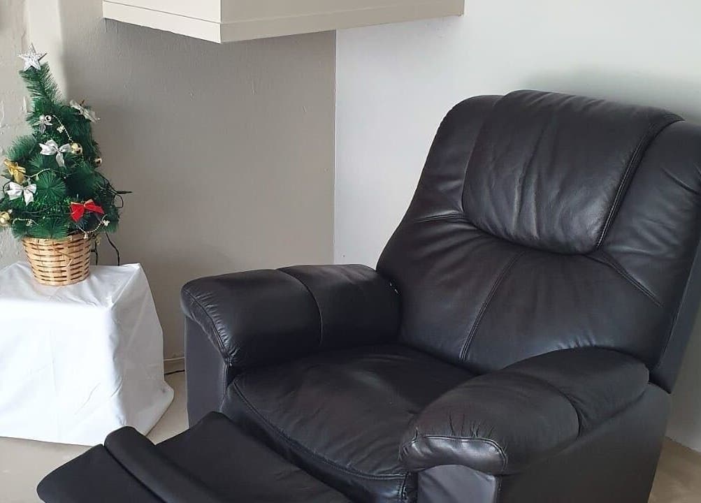 Comfortable black leather chair next to a festive mini tree at ALS Beauty, Cape Town, Western Cape, ZA.