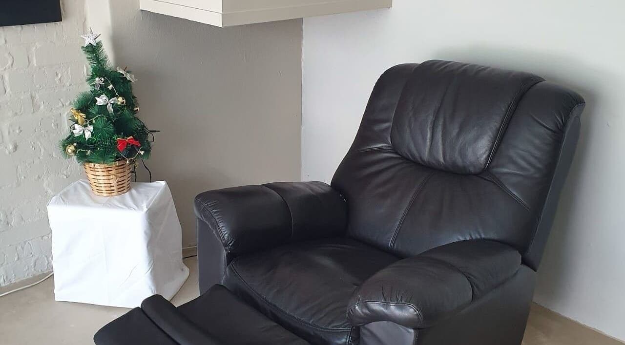 Comfortable black leather chair next to a festive mini tree at ALS Beauty, Cape Town, Western Cape, ZA.