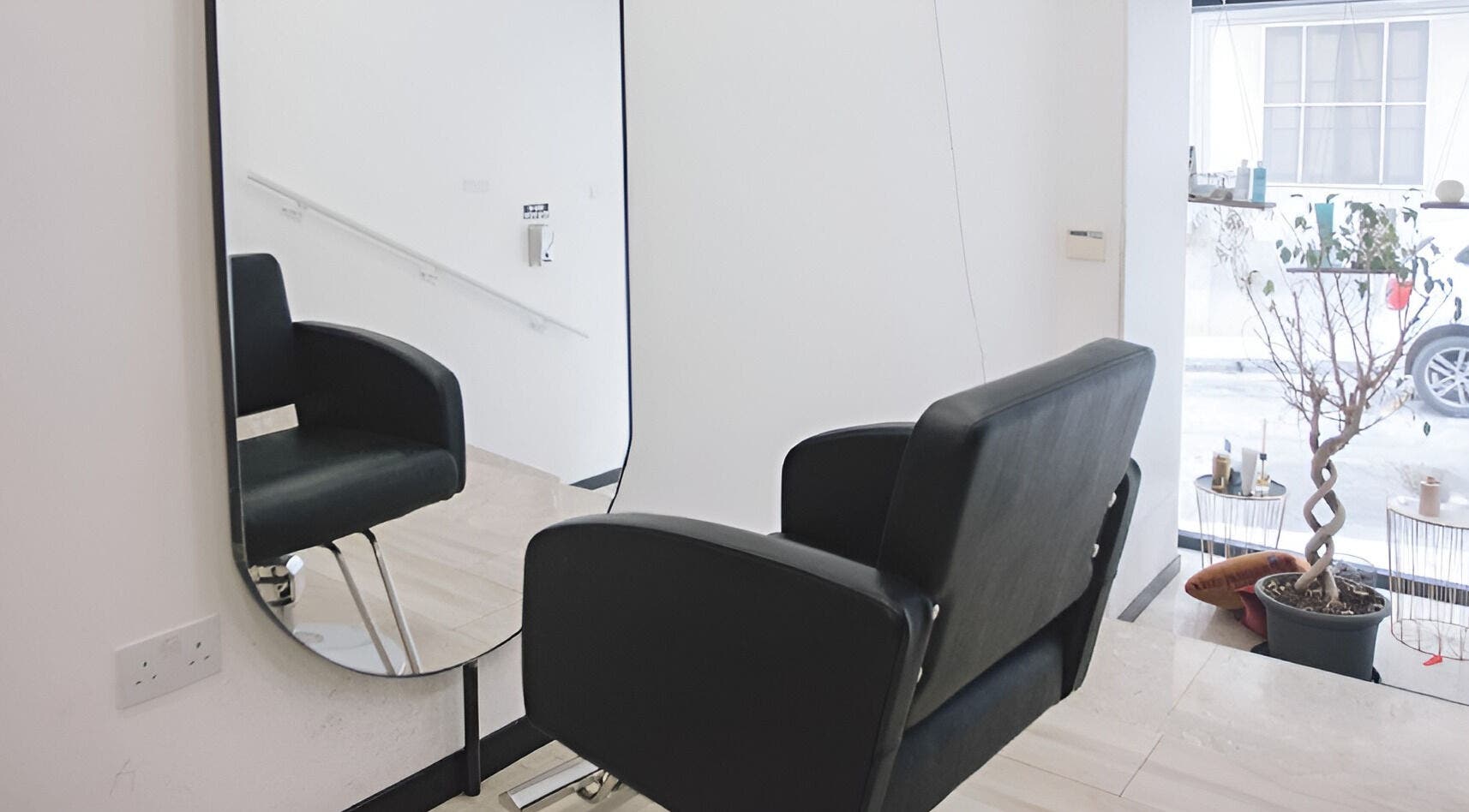 Modern salon chair and mirror at Elena Salon Sliema, Sliema, MT, showcasing sleek interior design.