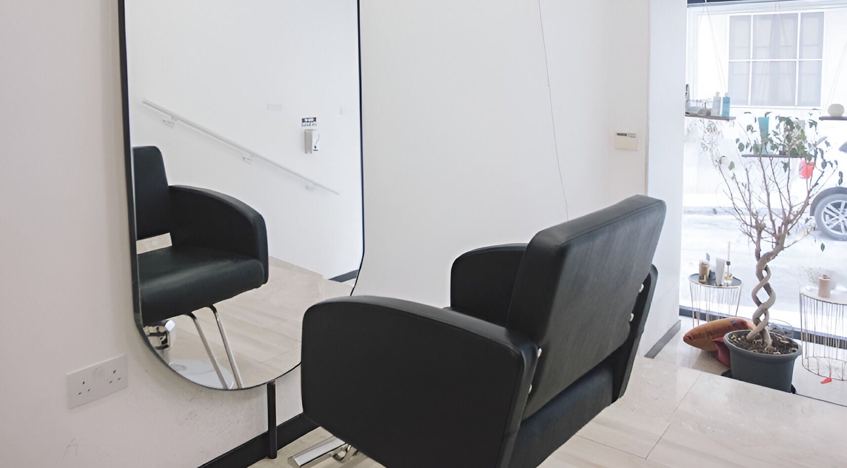 Modern salon chair and mirror at Elena Salon Sliema, Sliema, MT, showcasing sleek interior design.