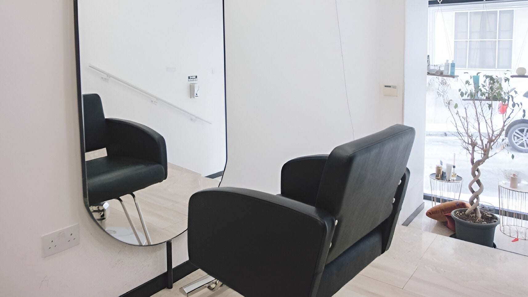 Modern salon chair and mirror at Elena Salon Sliema, Sliema, MT, showcasing sleek interior design.
