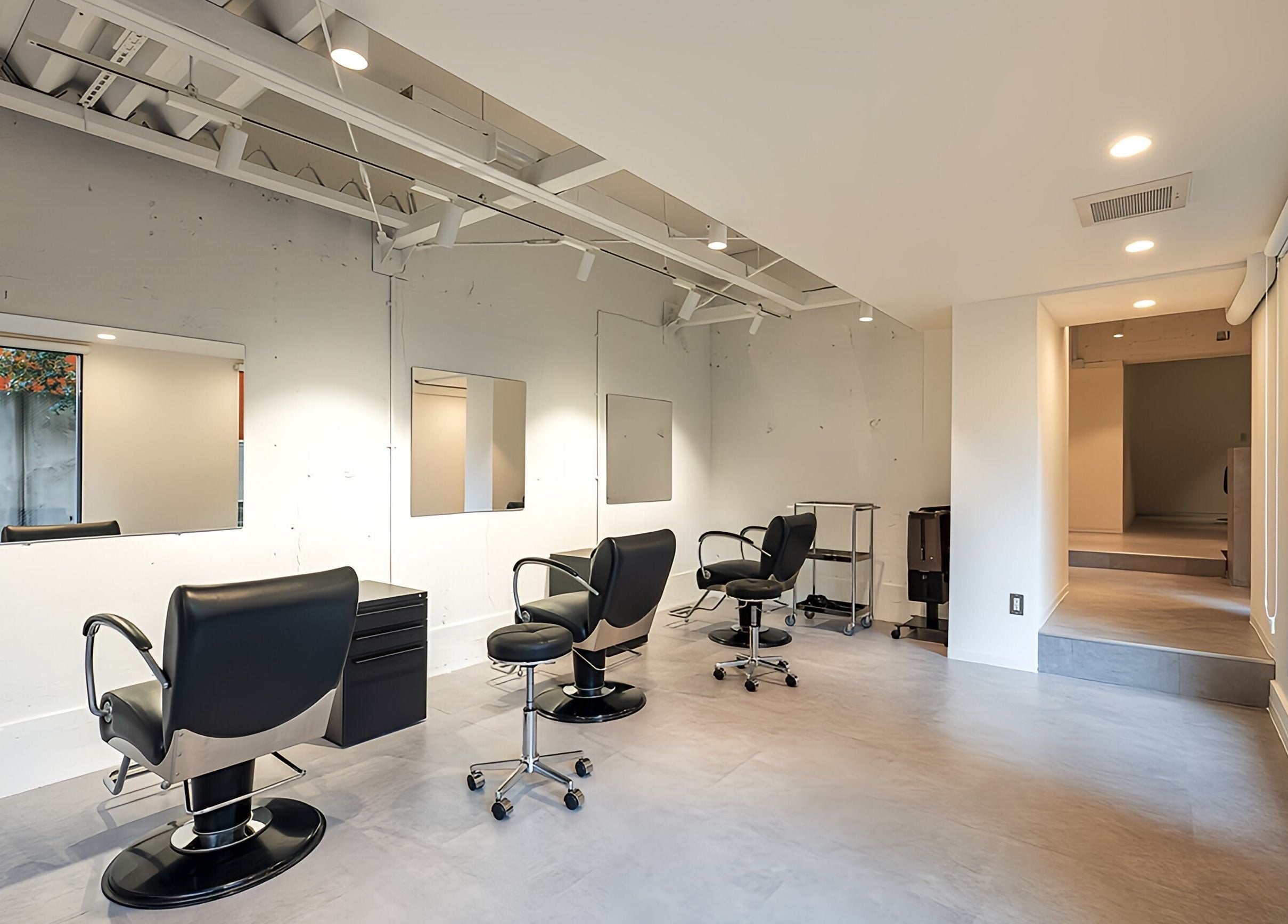 Modern beauty studio at FÈATH in Minato City, Tokyo, JP, showcasing sleek styling chairs and mirrors.