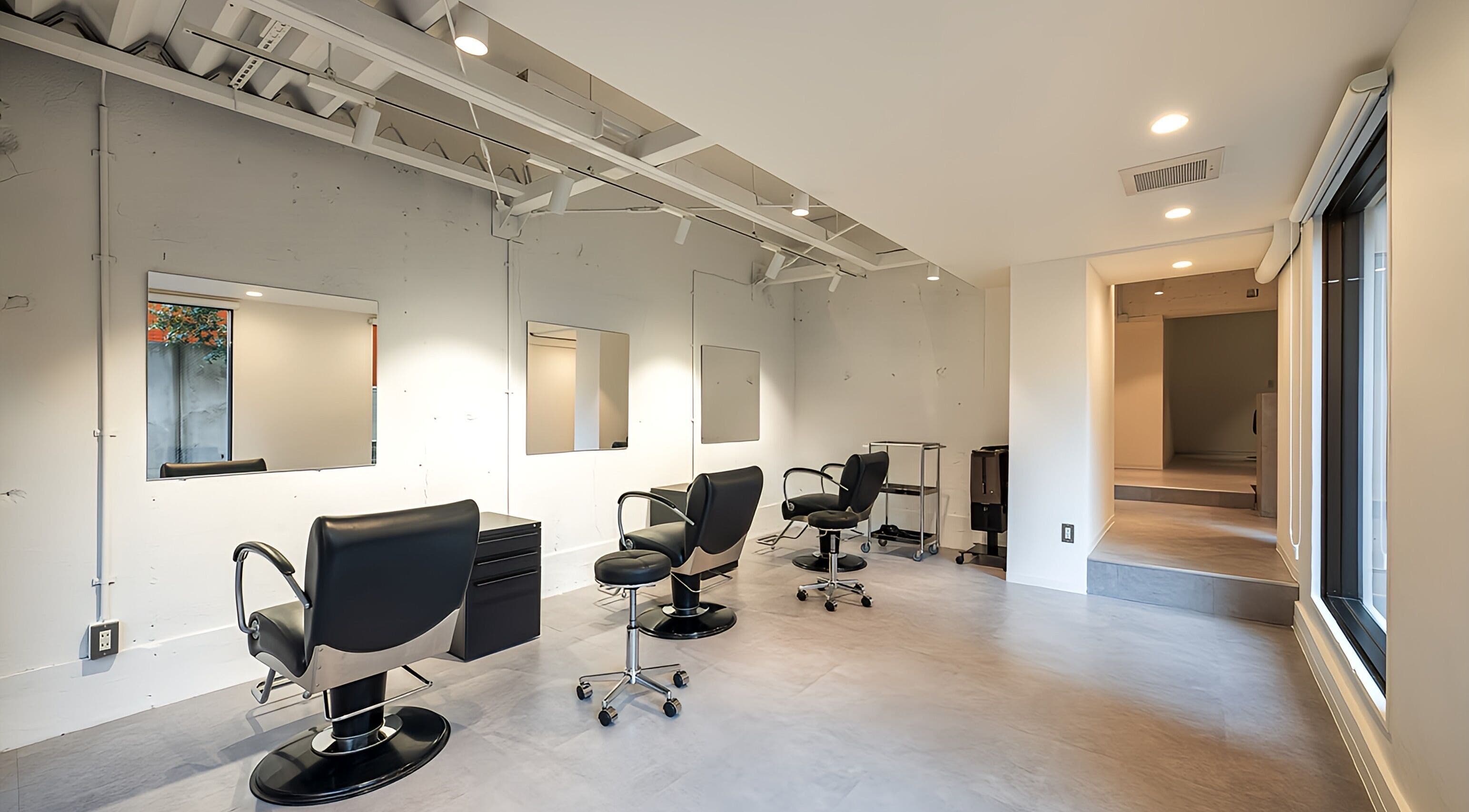 Modern beauty studio at FÈATH in Minato City, Tokyo, JP, showcasing sleek styling chairs and mirrors.