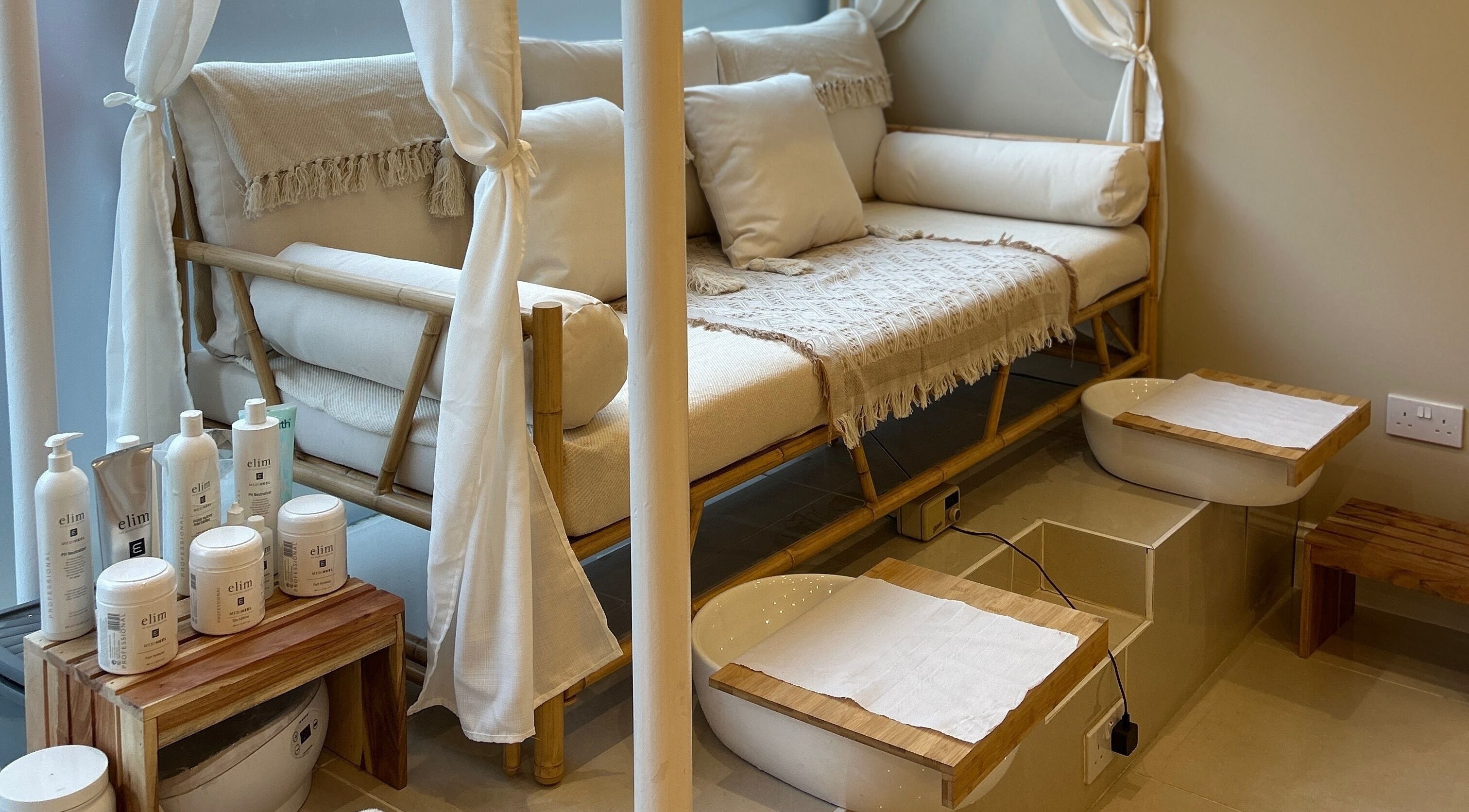 Elegant pedicure area at Ellie Glover Beauty, Lowestoft, England, GB with bamboo seating and skincare products.