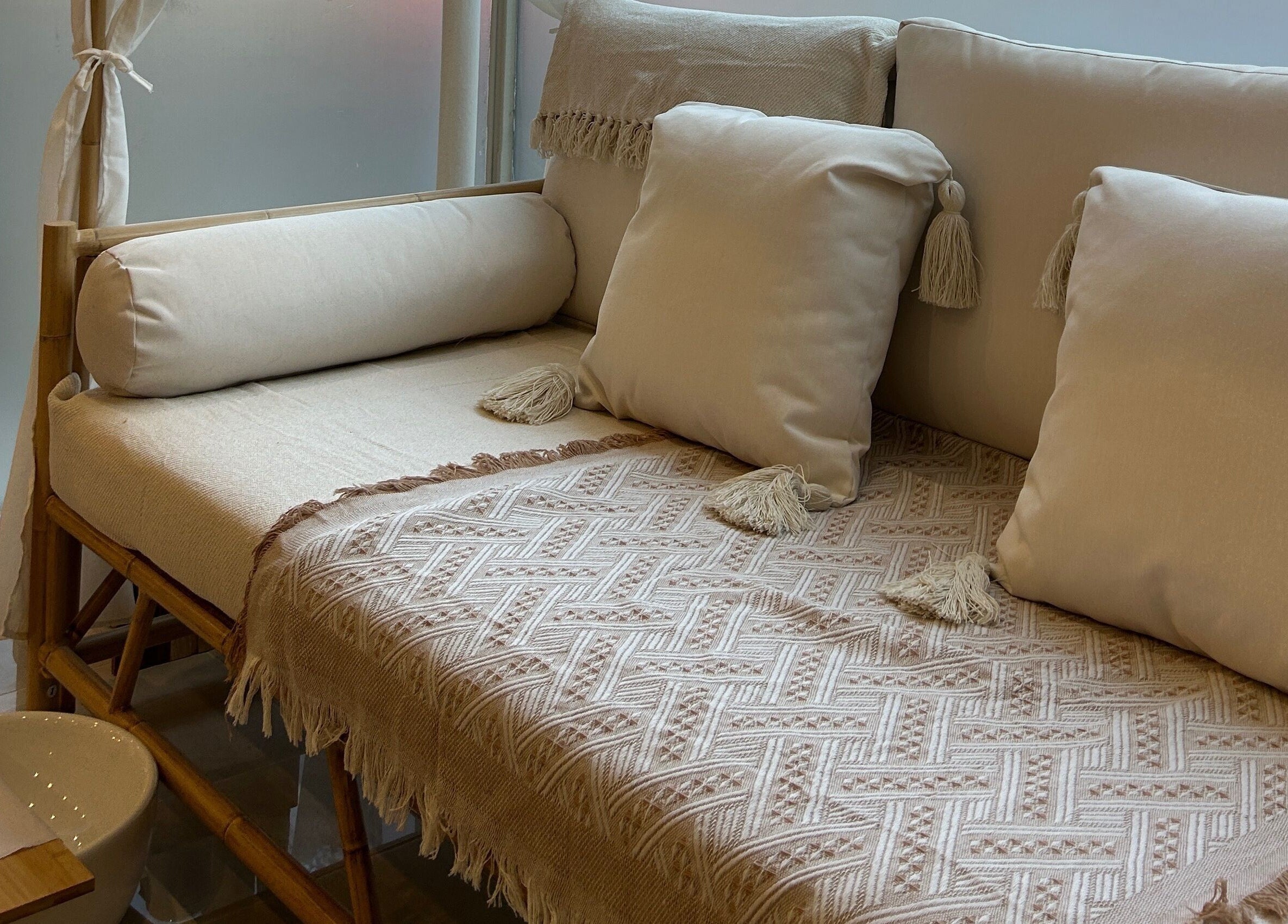 Elegant seating area at Ellie Glover Beauty, Lowestoft, England, GB, with plush pillows and textured throws.