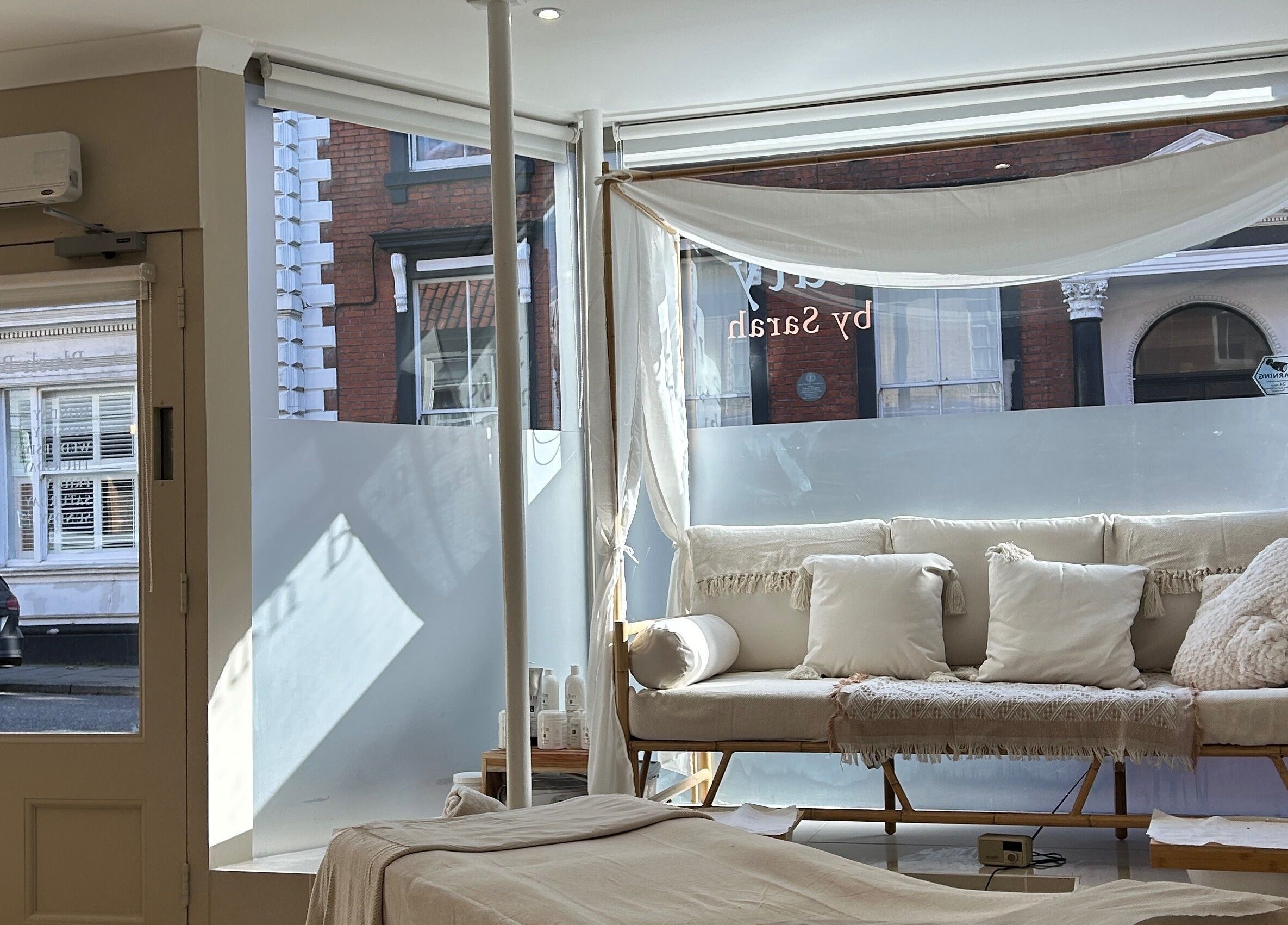 Serene interior of Ellie Glover Beauty, Lowestoft, England, GB with cozy seating and treatment area.