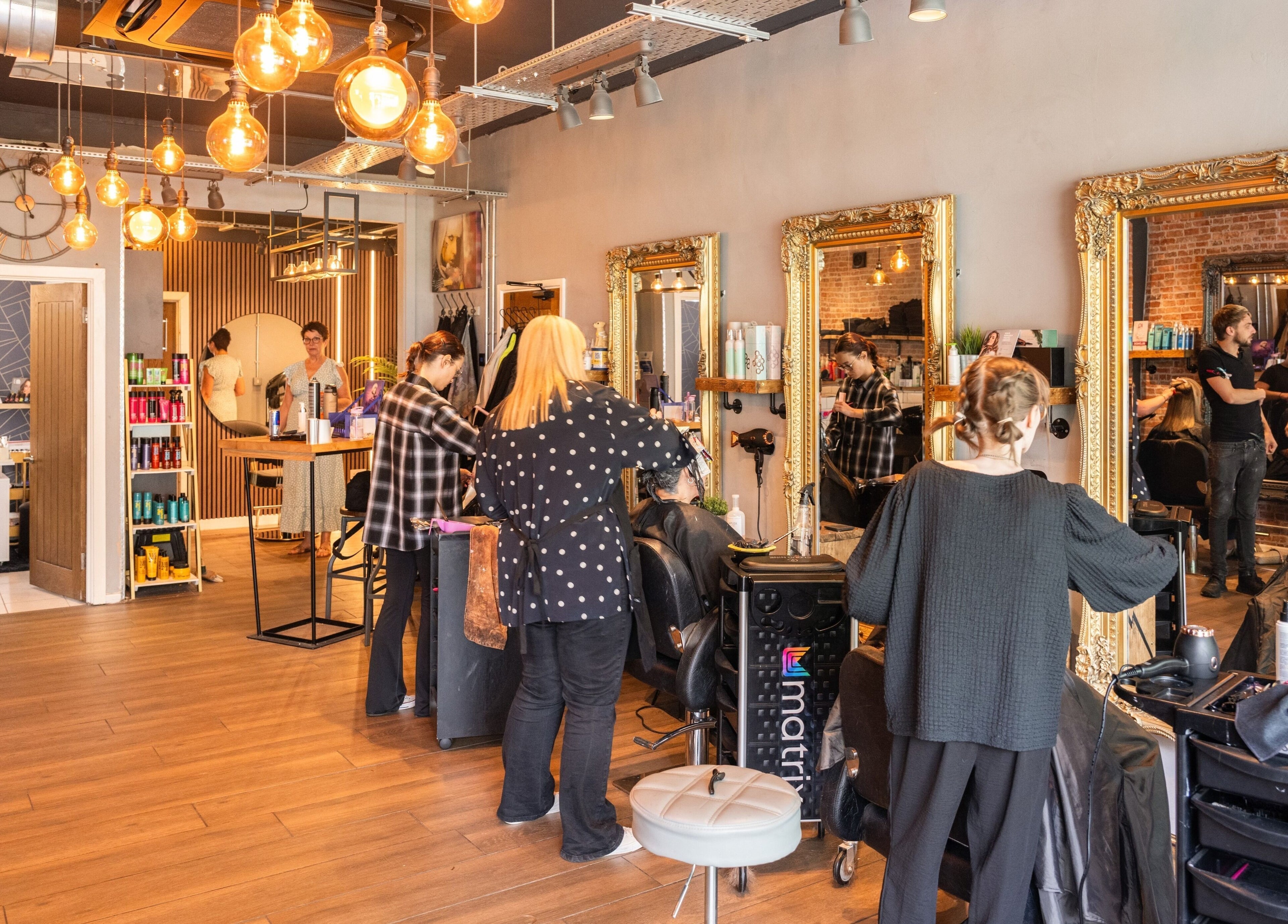 Stylish interior of Glam Factory in Nuneaton, England, GB, showing hairstylists at work in a vibrant atmosphere.