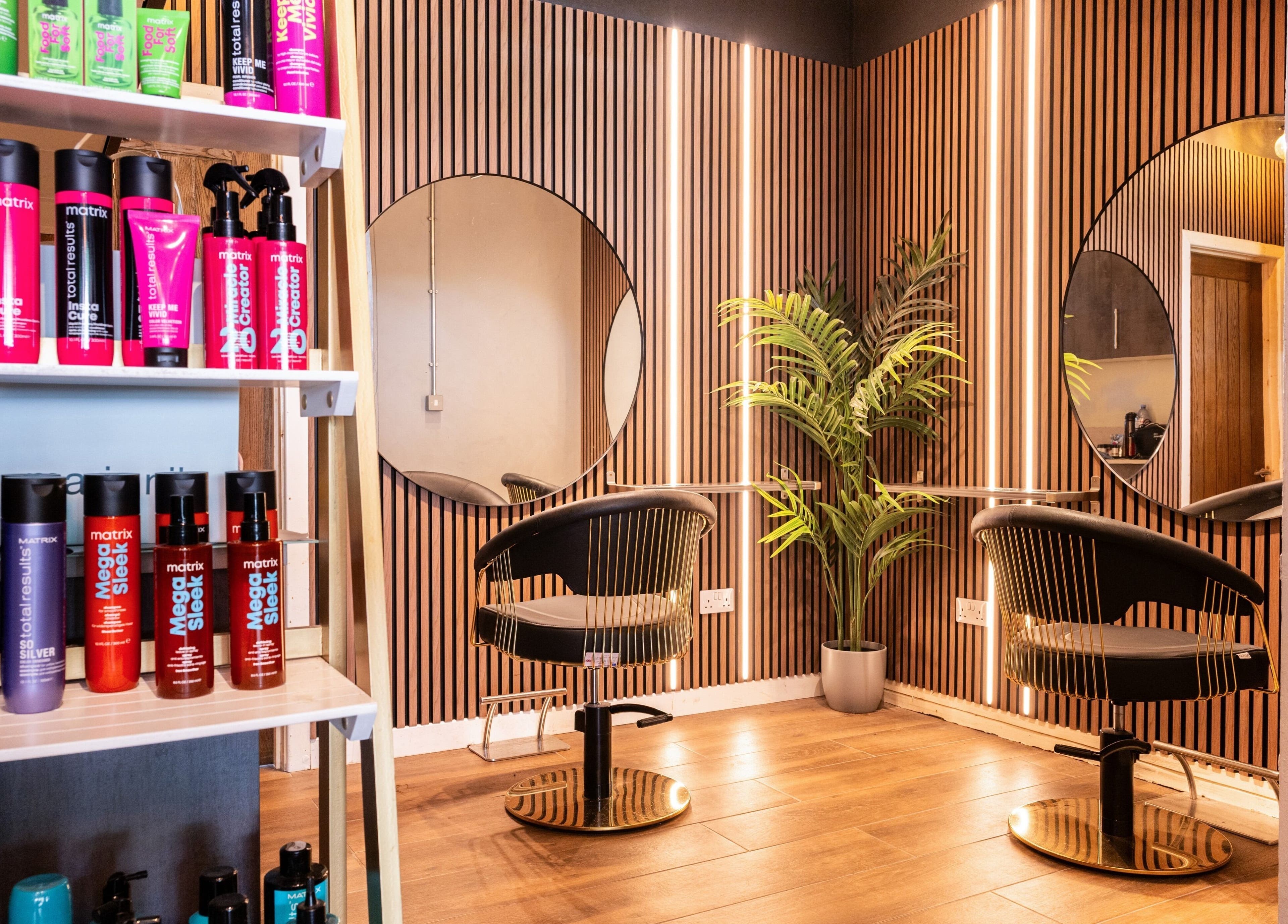 Stylish salon setup at Glam Factory, Nuneaton, England, GB with modern chair, mirror, and product shelf.