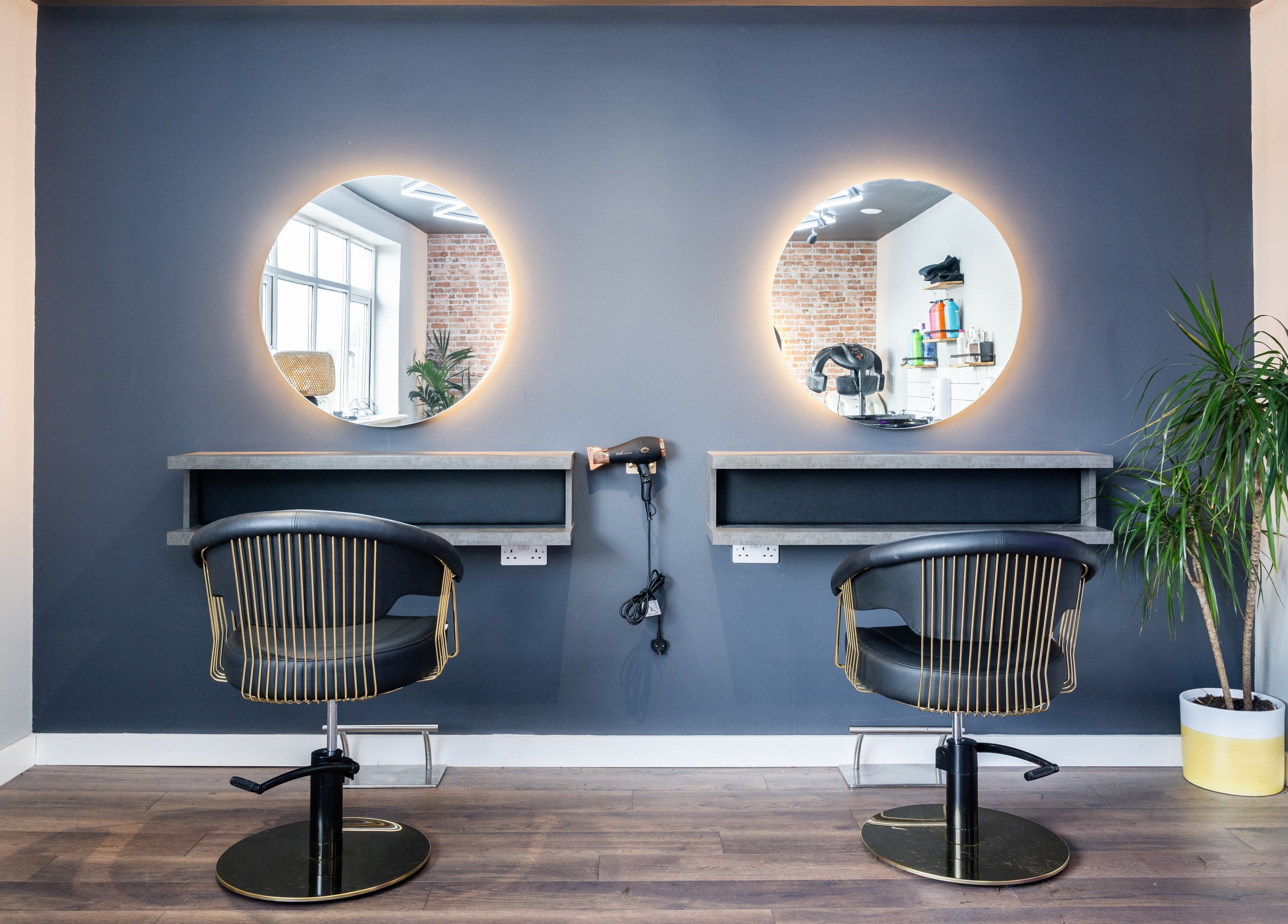 Chic styling stations at Glam Factory, Nuneaton, England, GB featuring modern mirrors and plush chairs.