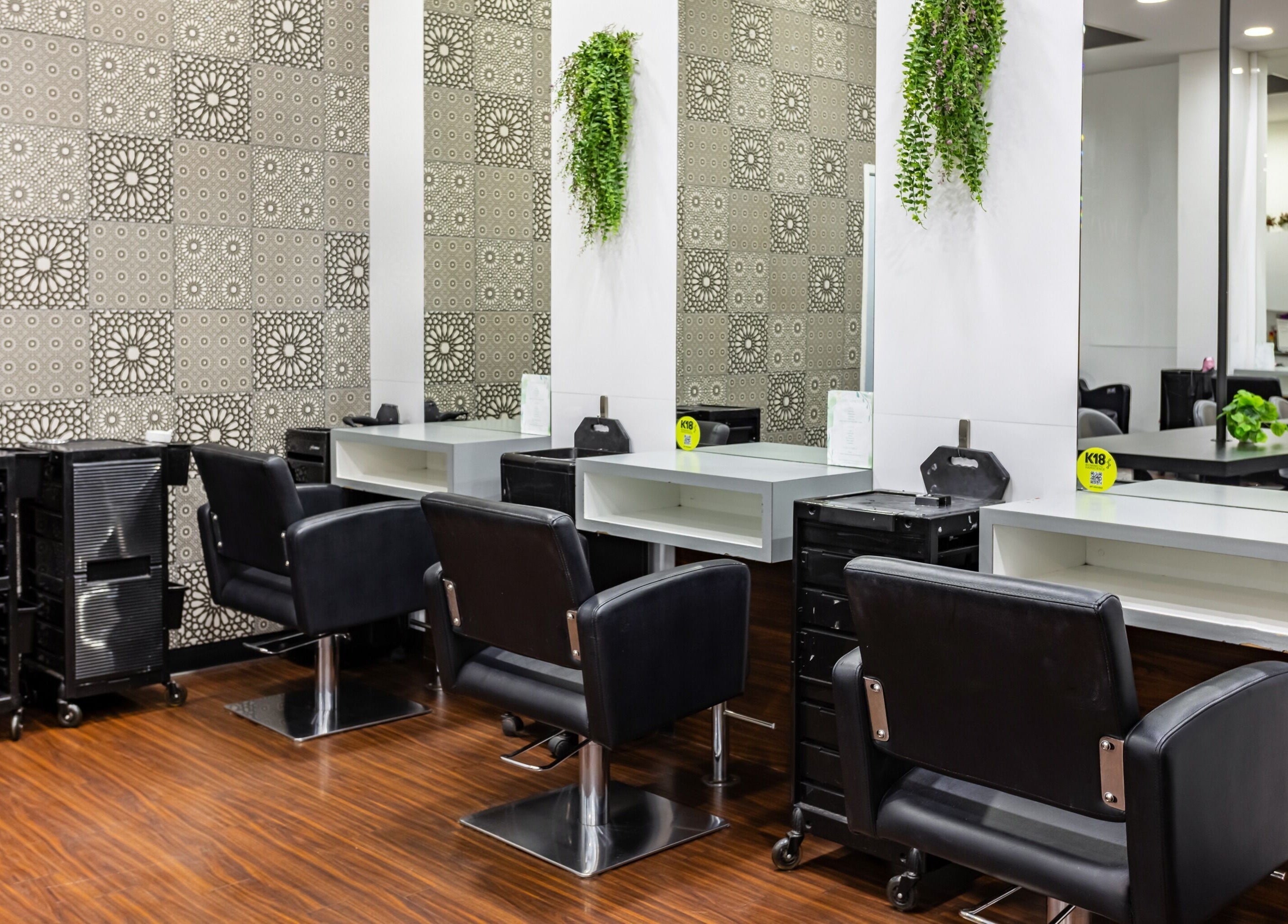 Stylish salon stations at Magnifique Salon in Springfield Central, Queensland, AU, equipped with modern black chairs.