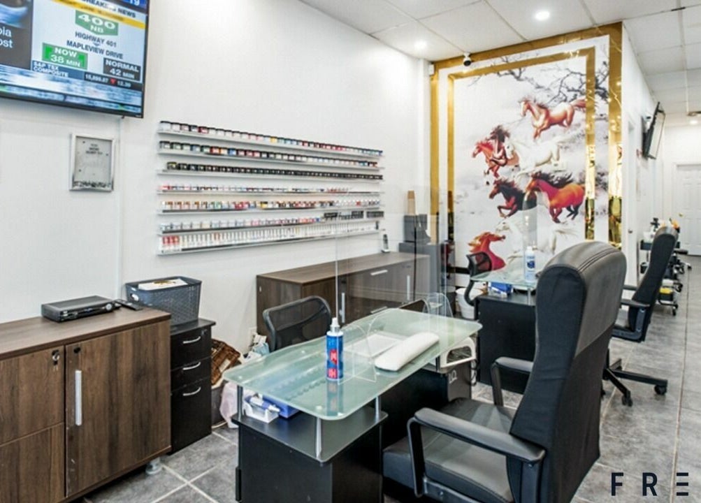 Modern interior of A.T. Nails, Mississauga, Ontario, CA showcasing nail services with sleek design and cozy chairs.