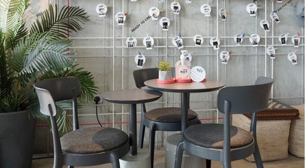 Stylish seating area at Not a Space in Sharjah, AE with modern decor and greenery.