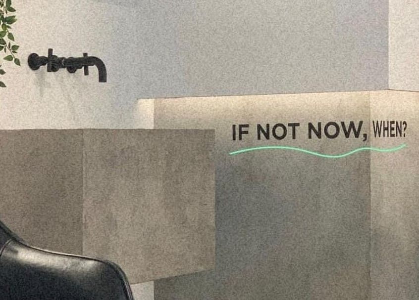 Modern decor at Not a Space, Sharjah, AE with a motivational 'If not now, when?' quote on the wall.