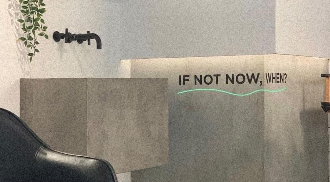 Modern decor at Not a Space, Sharjah, AE with a motivational 'If not now, when?' quote on the wall.