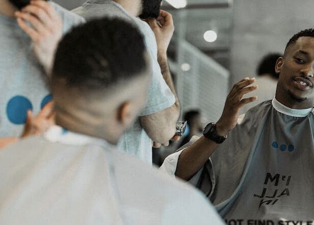 Barber and client engaging at Not a Space, Sharjah, AE, showcasing modern grooming services.