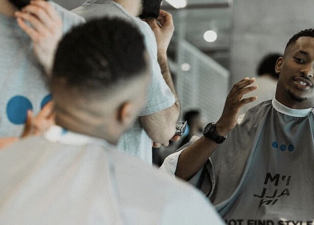 Barber and client engaging at Not a Space, Sharjah, AE, showcasing modern grooming services.