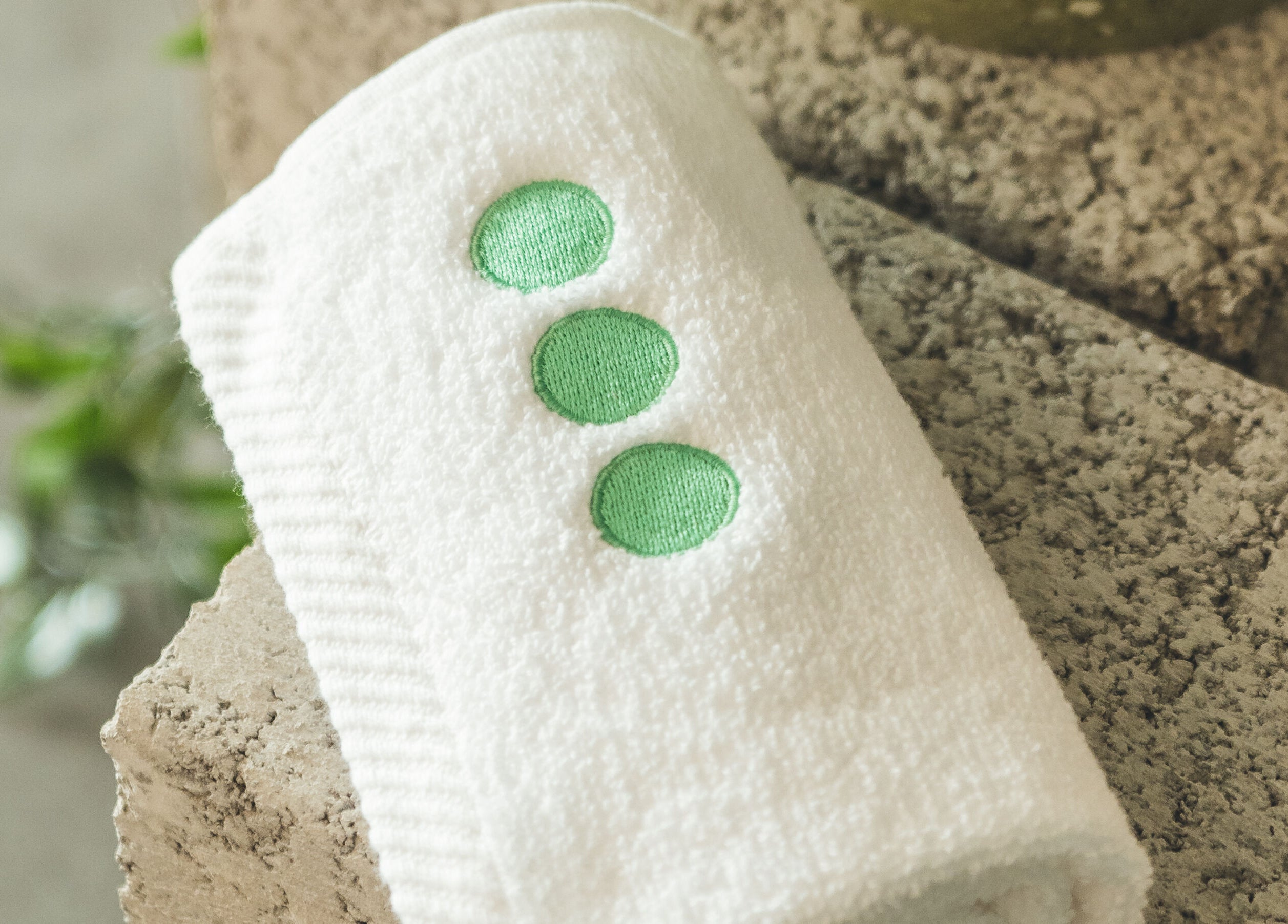 Luxurious white towel with green dots at Not a Space, Sharjah, AE, offering comfort and elegance.