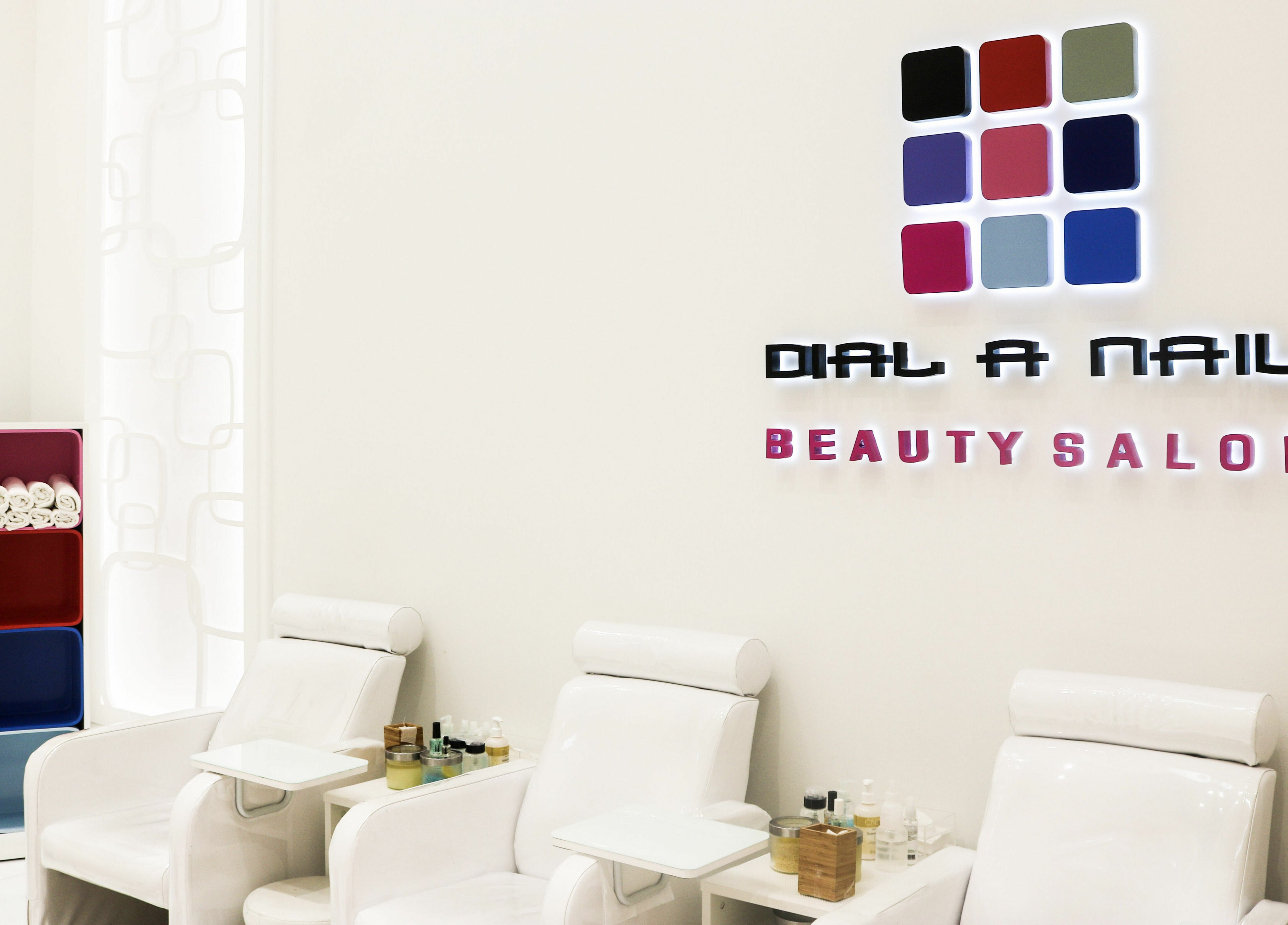 Modern interior of Dial A Nail - Palm in Dubai, Dubai, AE with stylish chairs and organized shelves.