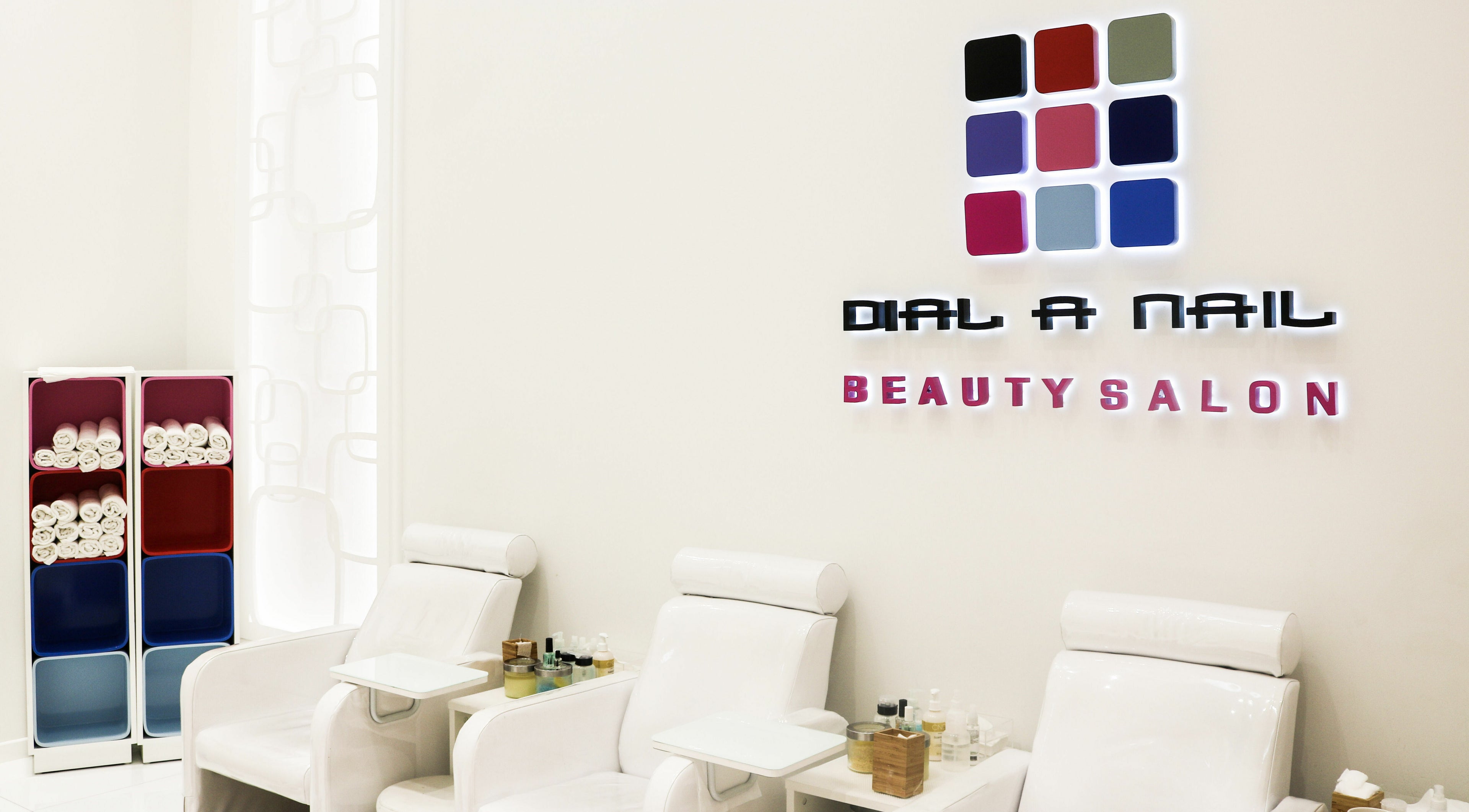 Modern interior of Dial A Nail - Palm in Dubai, Dubai, AE with stylish chairs and organized shelves.