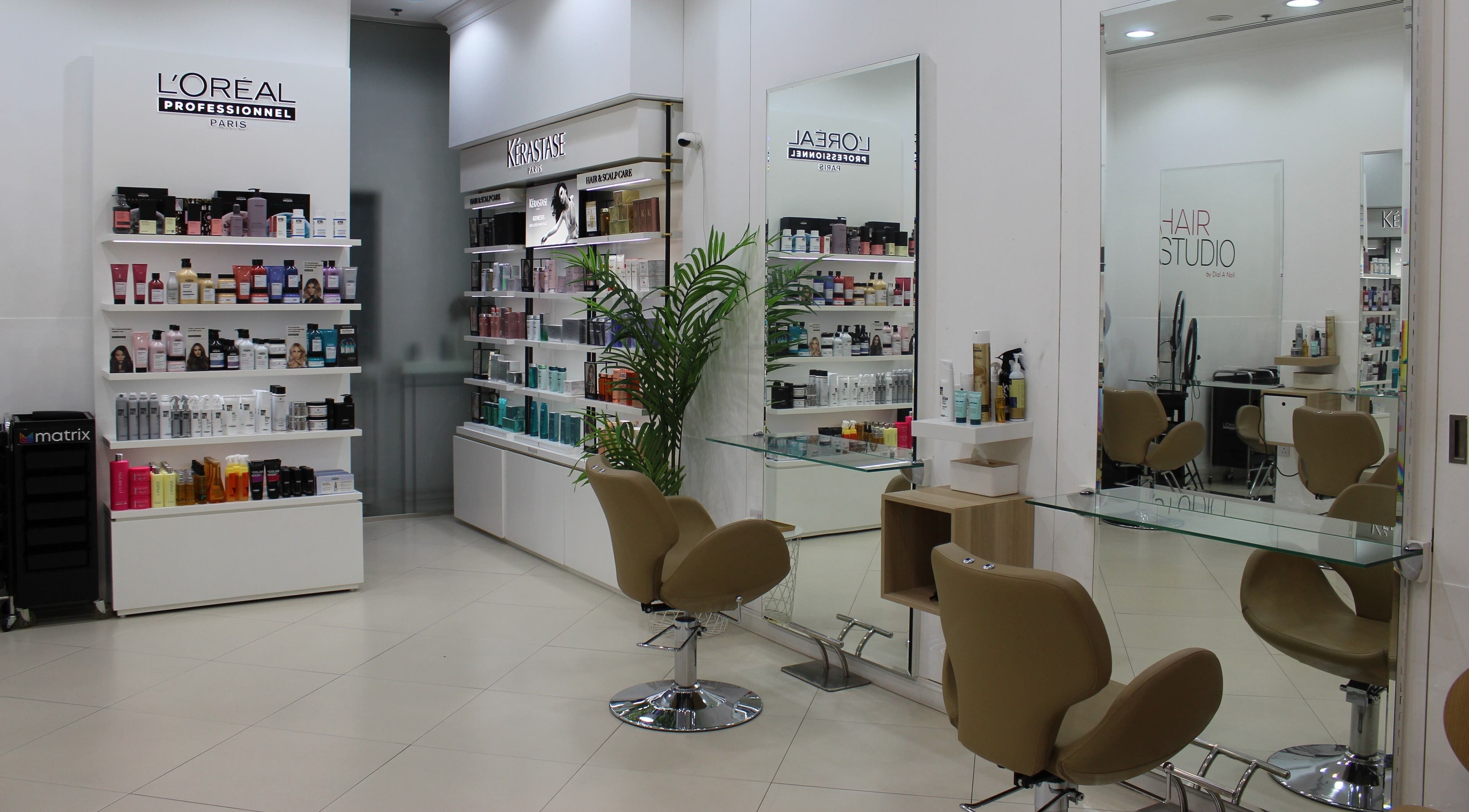 Inside Dial A Nail - Boulevard, Dubai, AE salon with chic seating and shelves of beauty products.