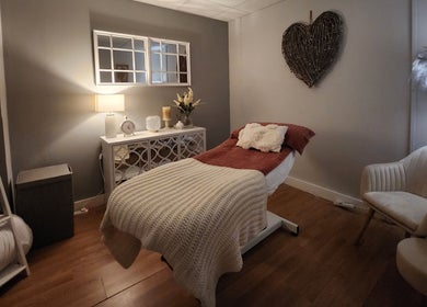 Calming treatment room at The Amber Boutique, Milford Haven, Wales, GB, with a cozy bed and soft lighting.