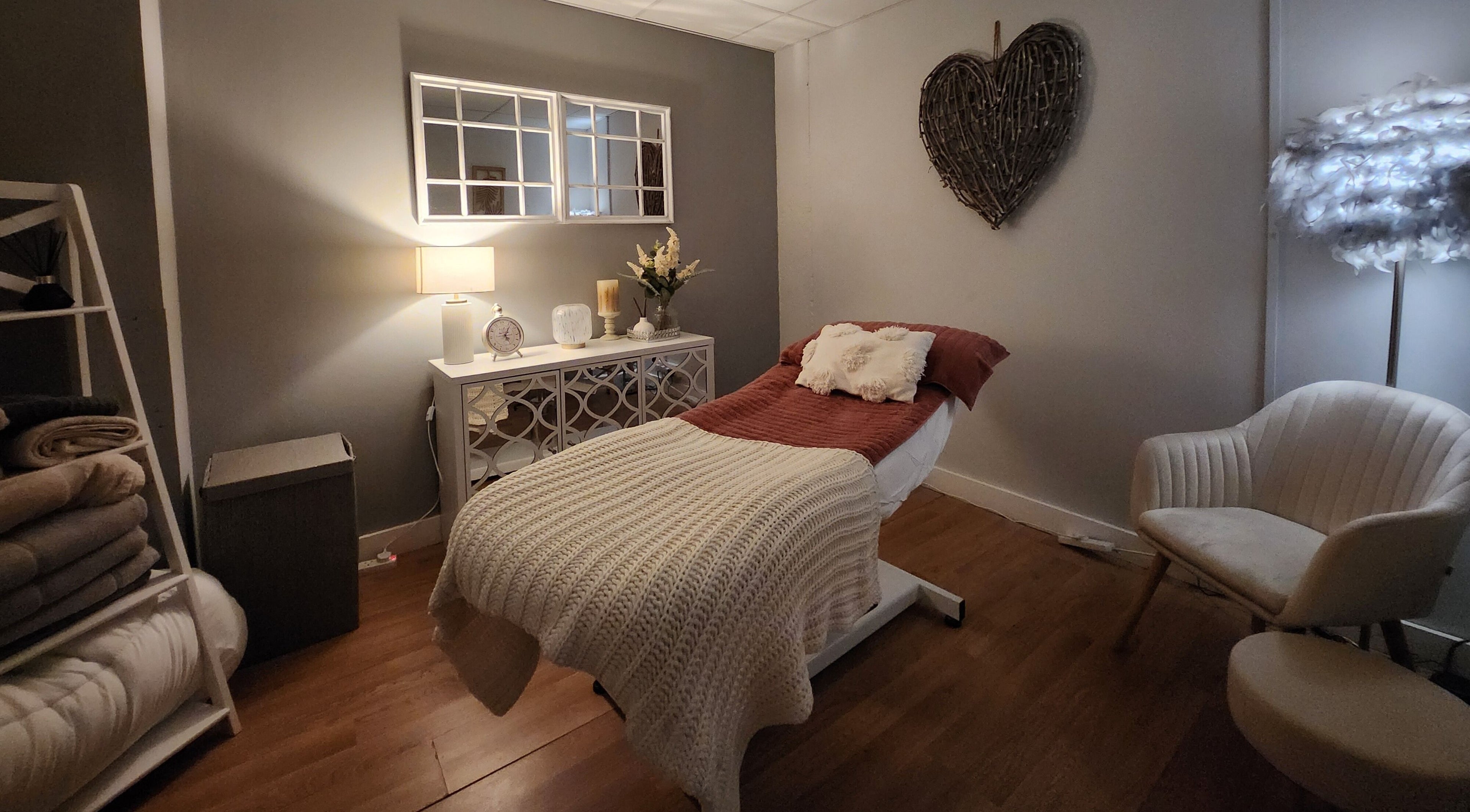Calming treatment room at The Amber Boutique, Milford Haven, Wales, GB, with a cozy bed and soft lighting.