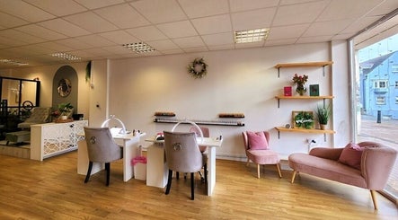 Elegant interior of The Amber Boutique, Milford Haven, Wales, GB, showcasing nail stations and cozy seating.