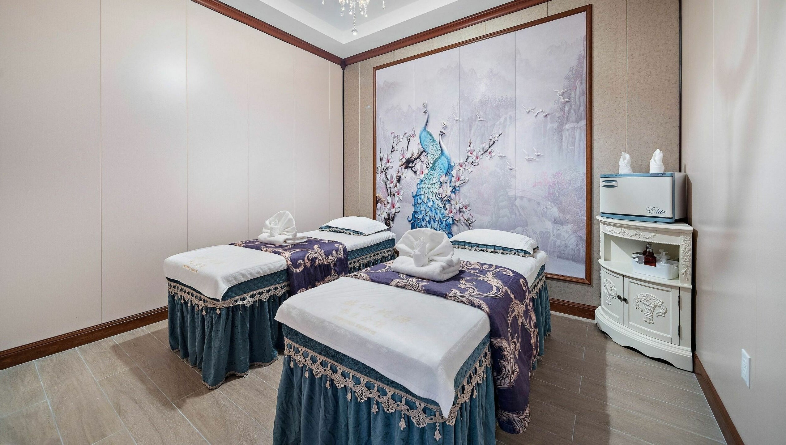 Relaxing dual massage beds at Prosperous Paradise Spa in Houston, Texas, US with elegant peacock artwork.